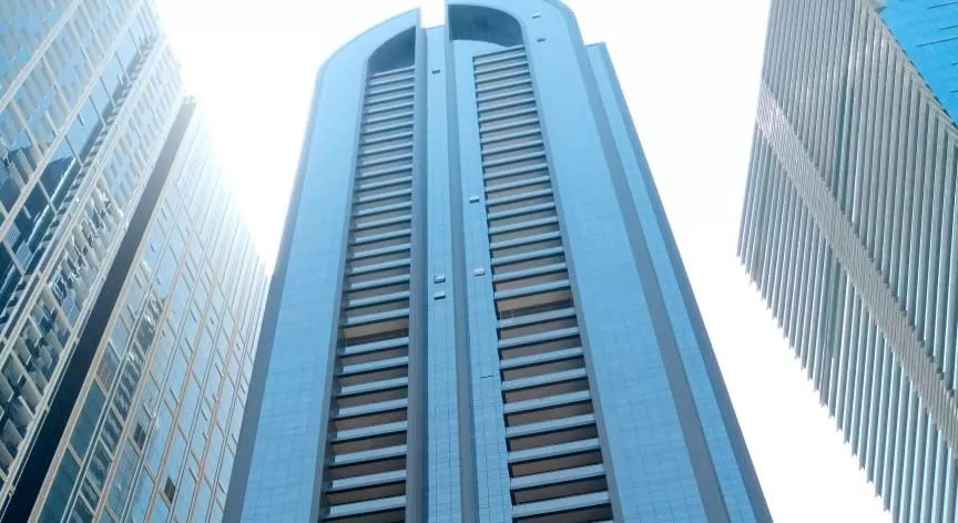 Low-angle view of Duja Tower’s impressive glass exterior reaching toward the sky in the business district.