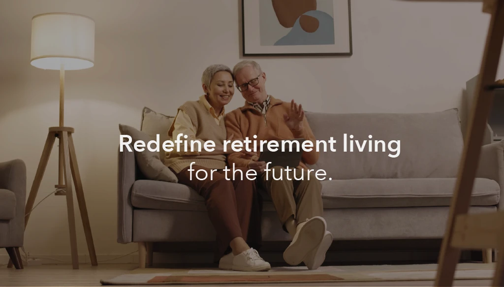an image of a retirement aged-couple sitting in a modern apartment, with the text 'redefine retirement living for the future' inlayed.