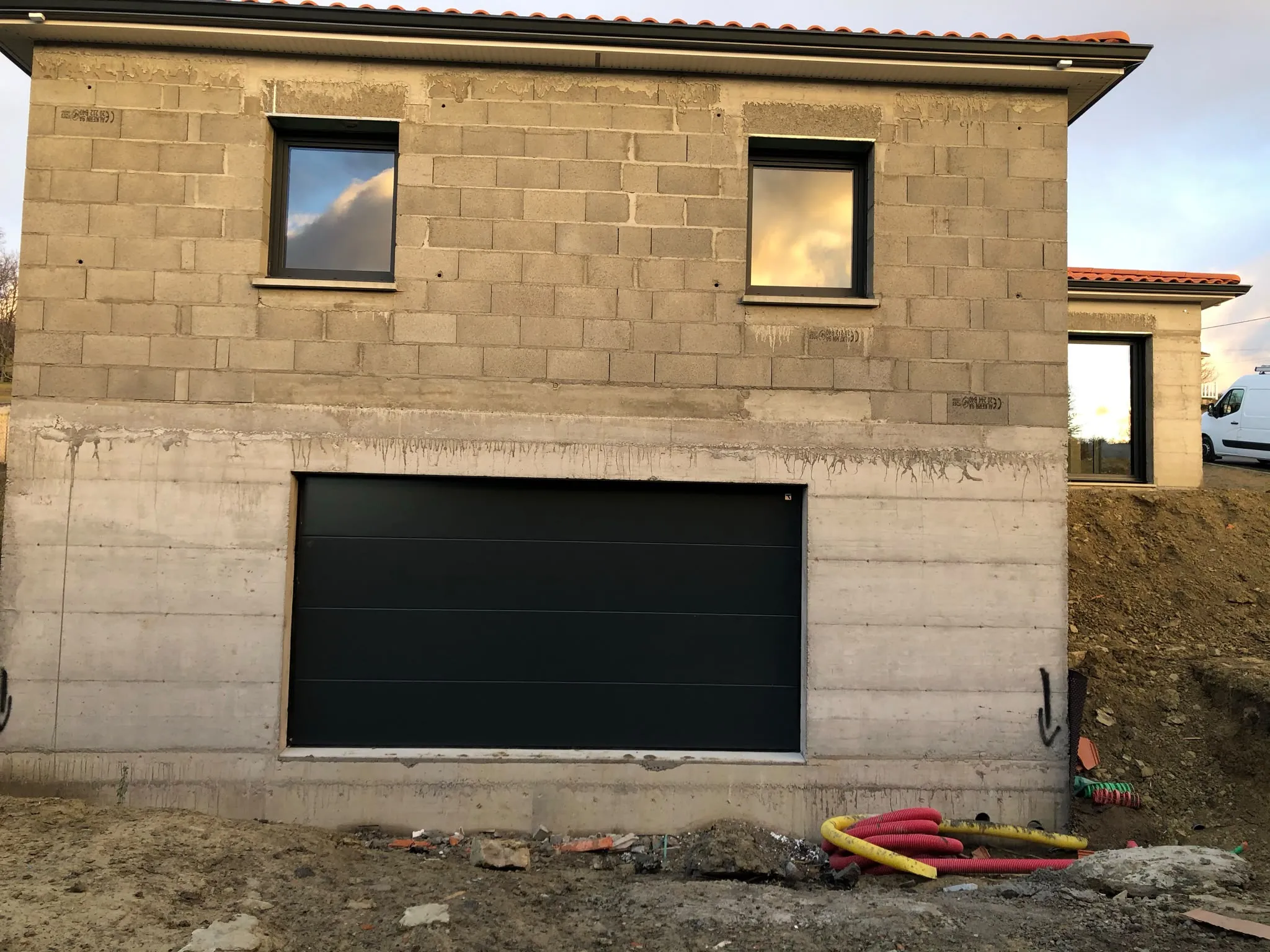 Porte de garage sombre dans une façade en pierre — AFermetures
