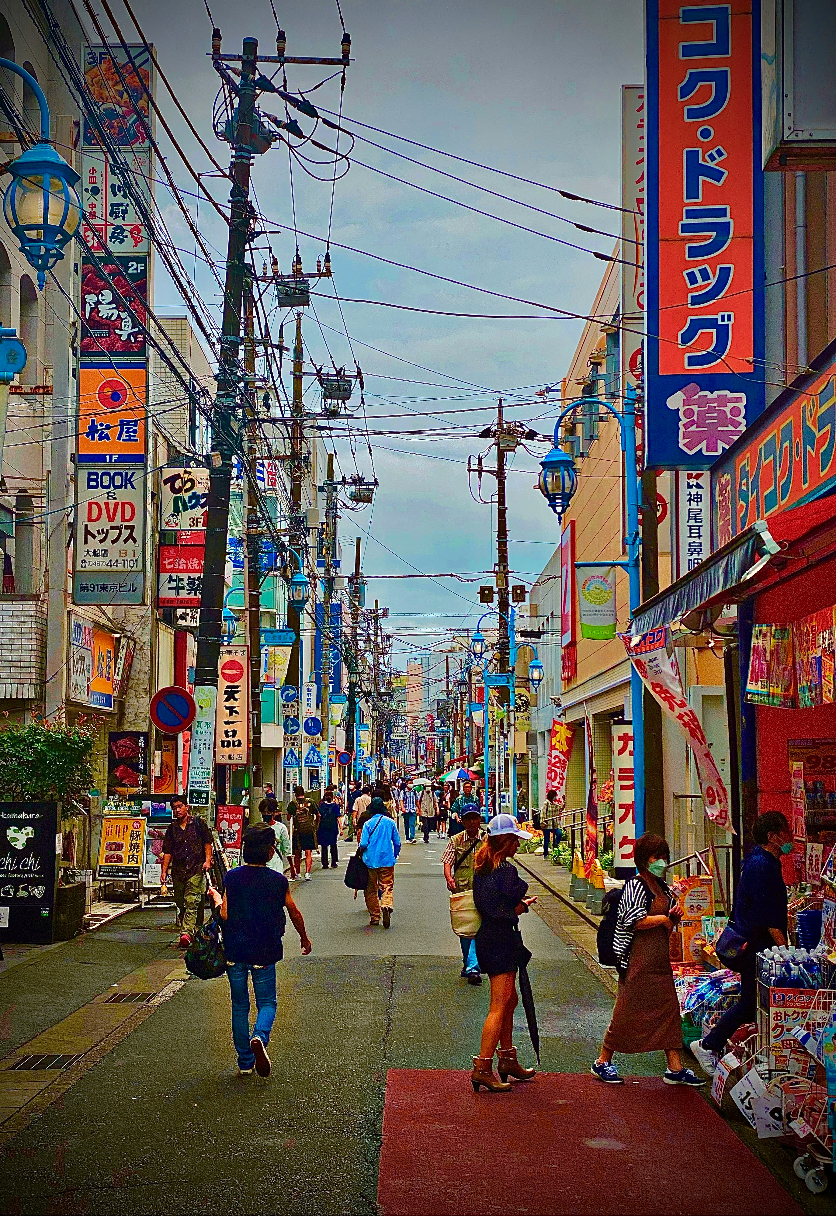 a group of people walking down a street next to tall buildings