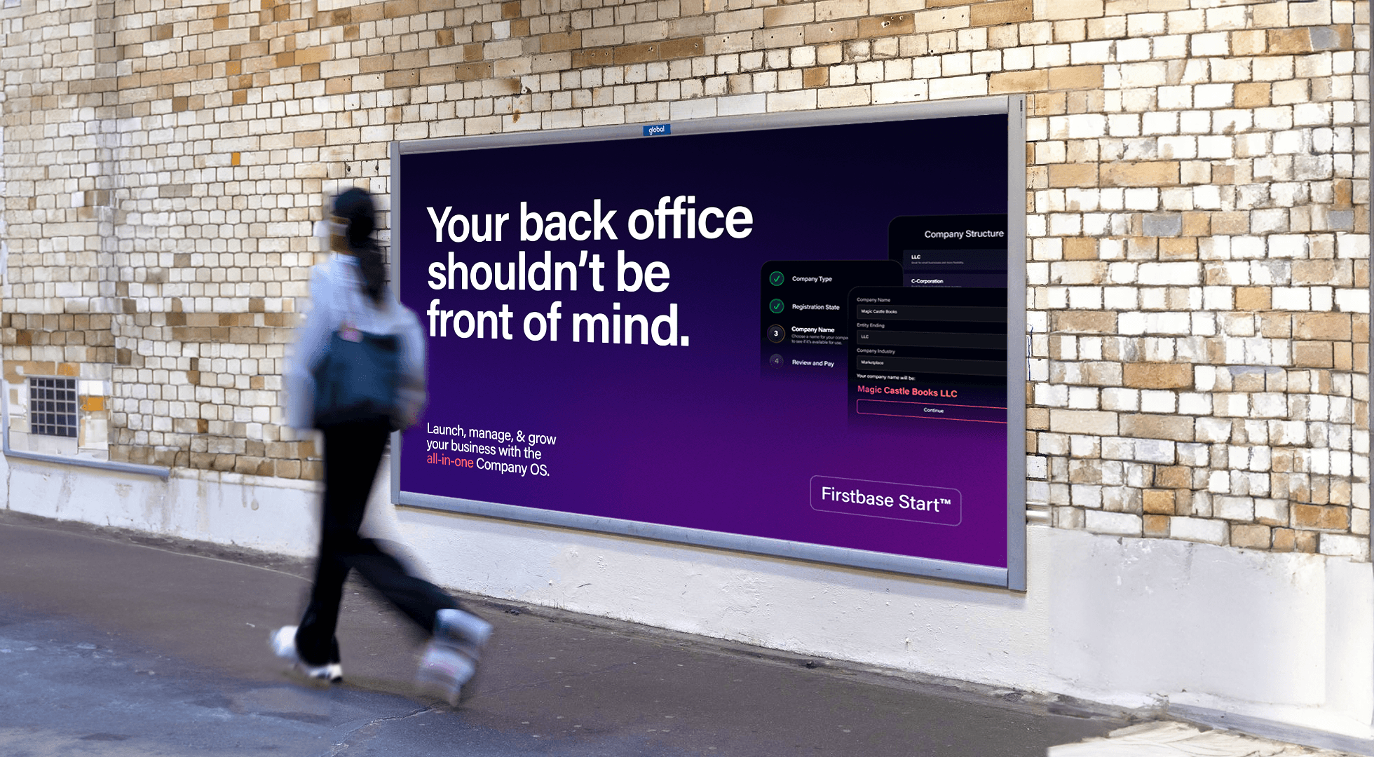 woman walking past a billboard for firstbase on a brick wall