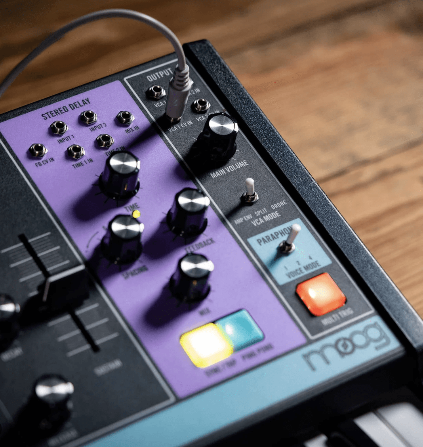 Analog synthesizer control panel with knobs and switches, close-up view on wooden surface