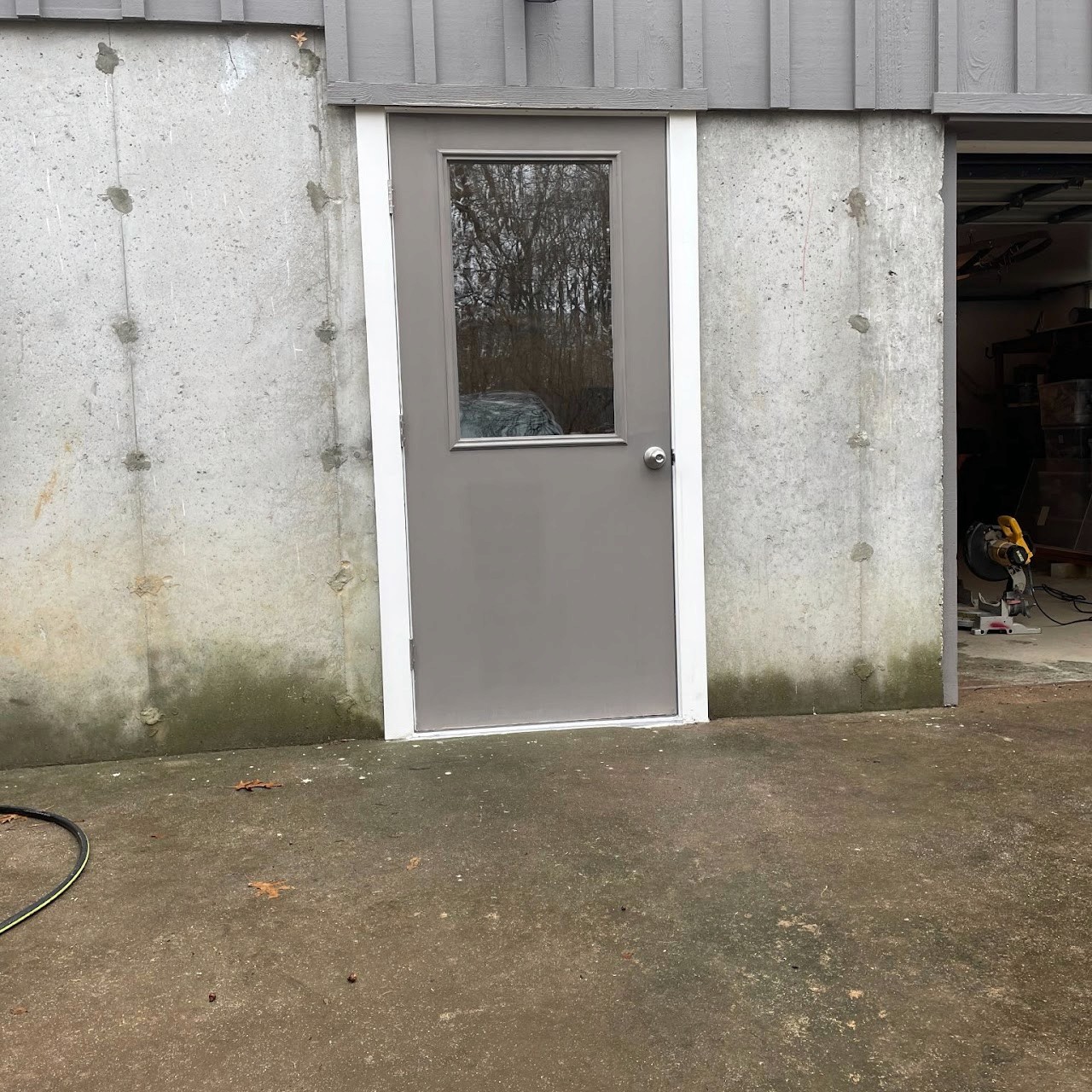 New gray steel garage entry door installed in concrete block wall
