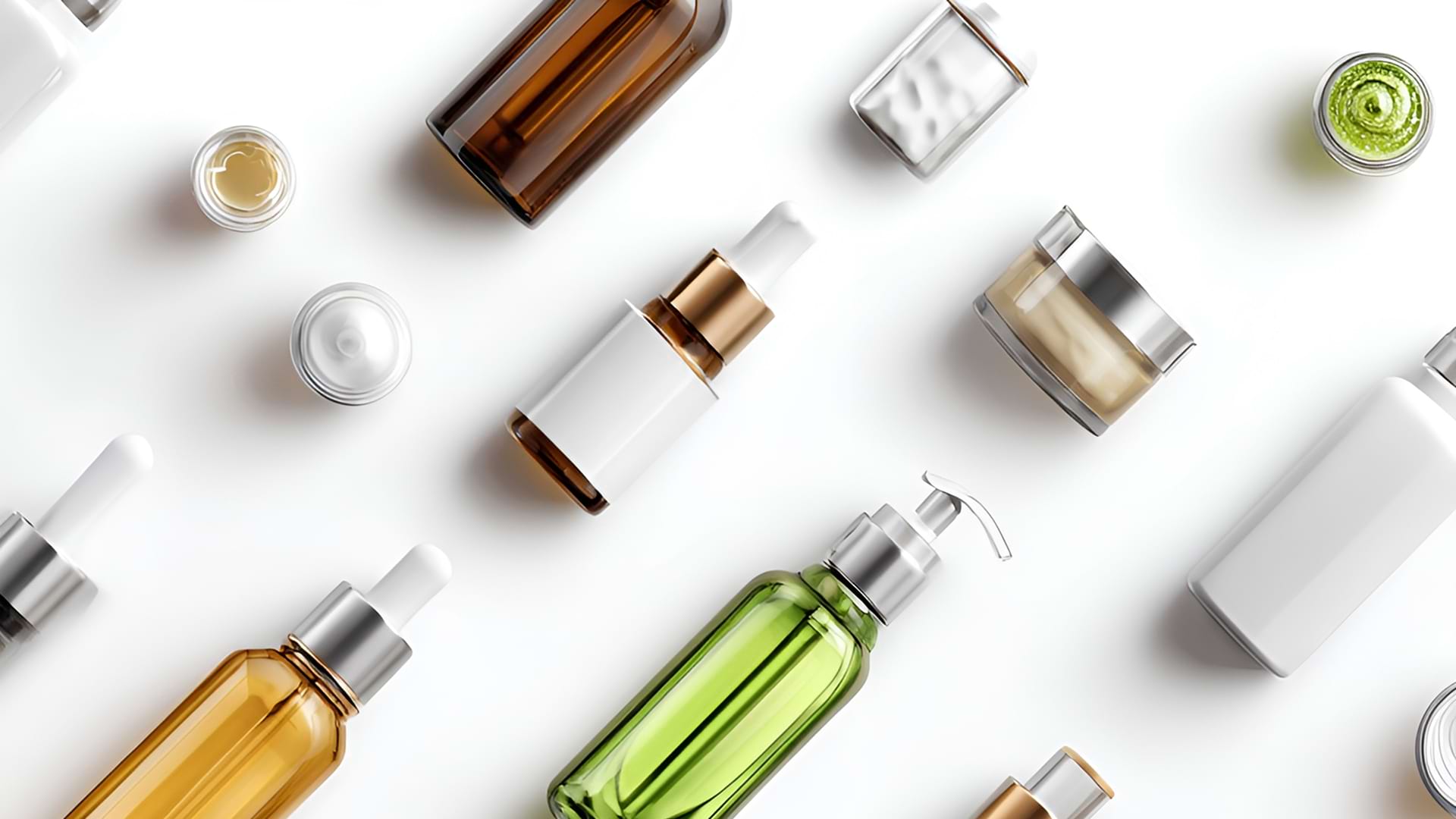 Assorted skincare products displayed on a white background, including bottles and jars in green, brown, and white, featuring various caps and lids.