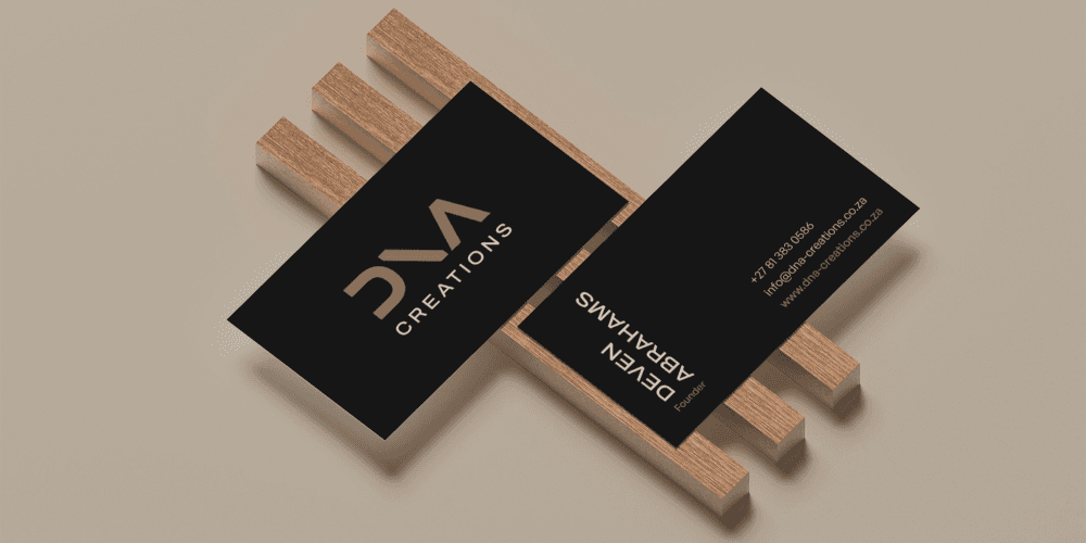 Two business cards that are displayed on wood.