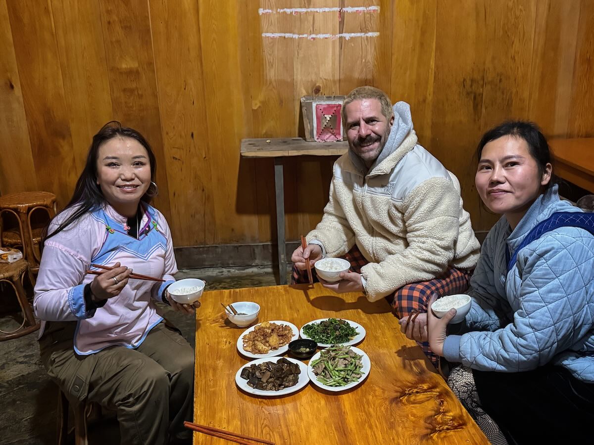 Guests sharing a traditional meal with a local family inside a homestay near Sapa.