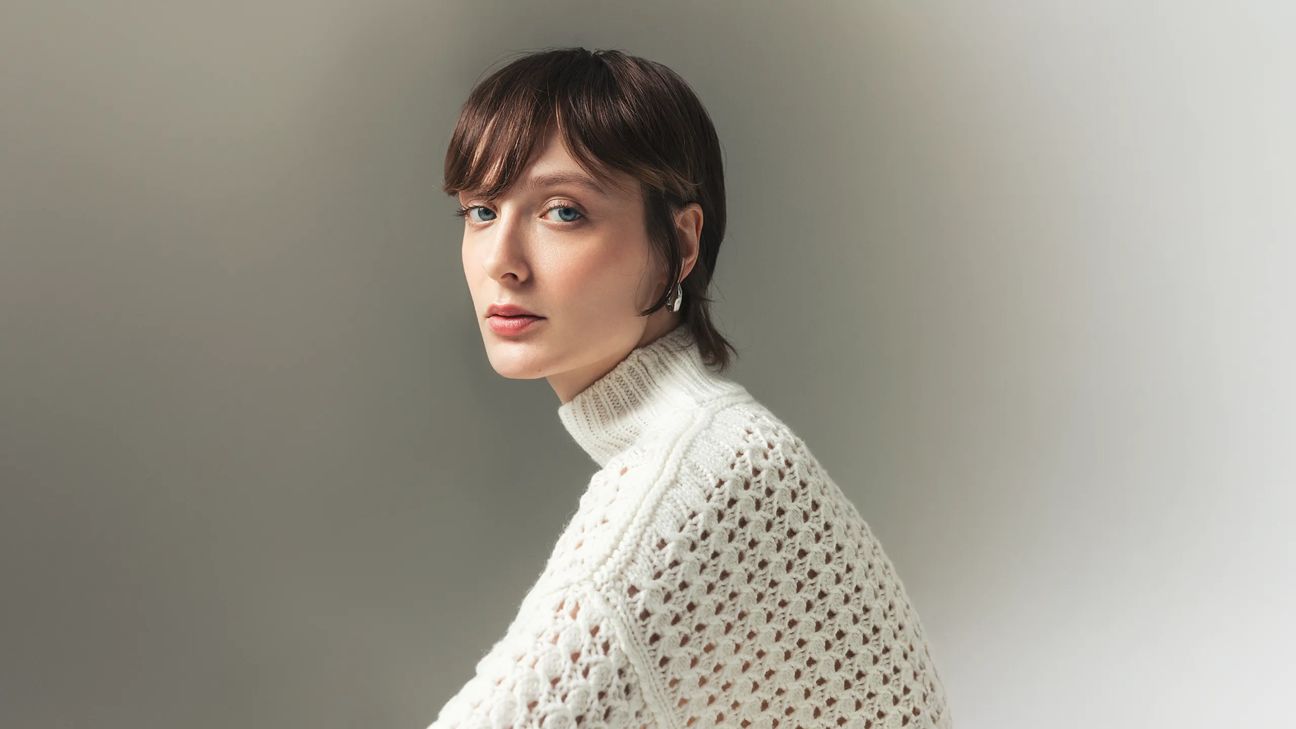 Woman wearing white open-knit cashmere sweater by Aida Barni – Italian craftsmanship and timeless design.