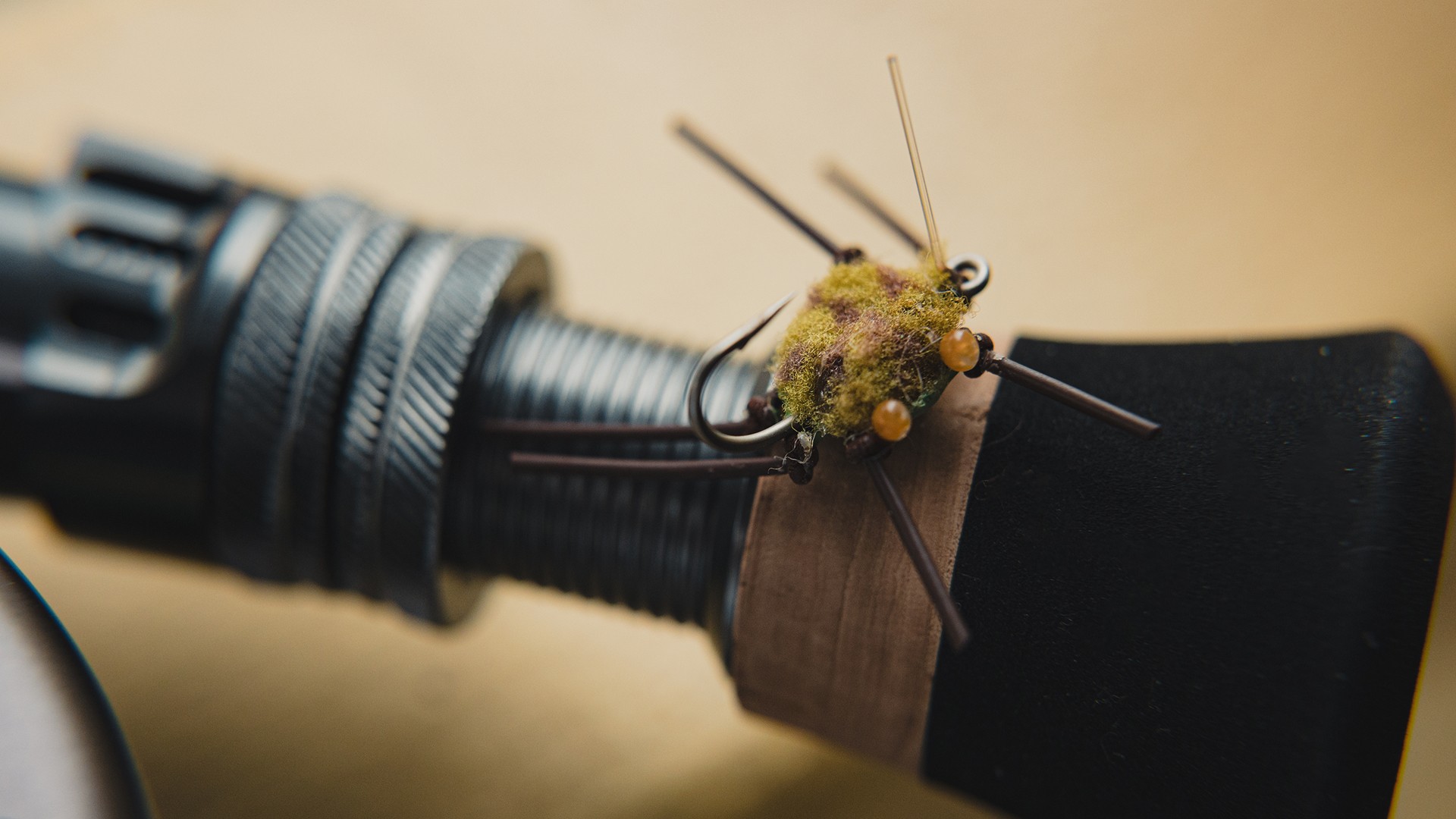 A closeup of a Bauer Crab fly on top of a fly fishing rod handle