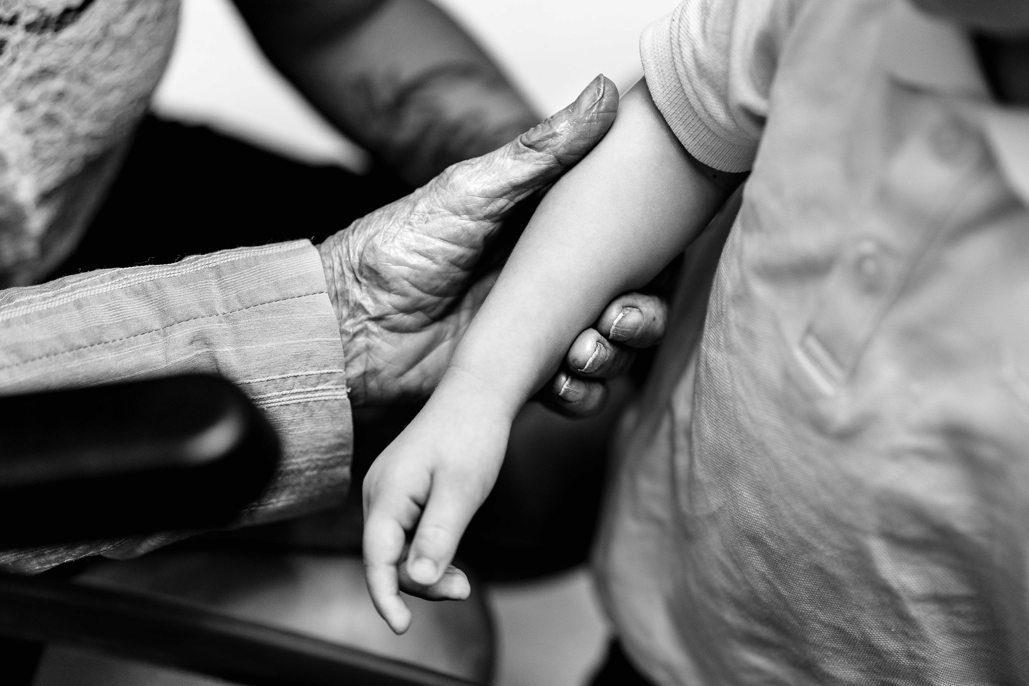 détail émouvant d'une main agée touchant le bras d'un jeune enfant pendant un mariage civil a la mairie de Biarritz au pays basque