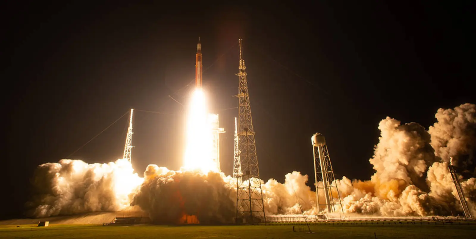 NASA Artemis I rocket launching from Kennedy Space Center at night