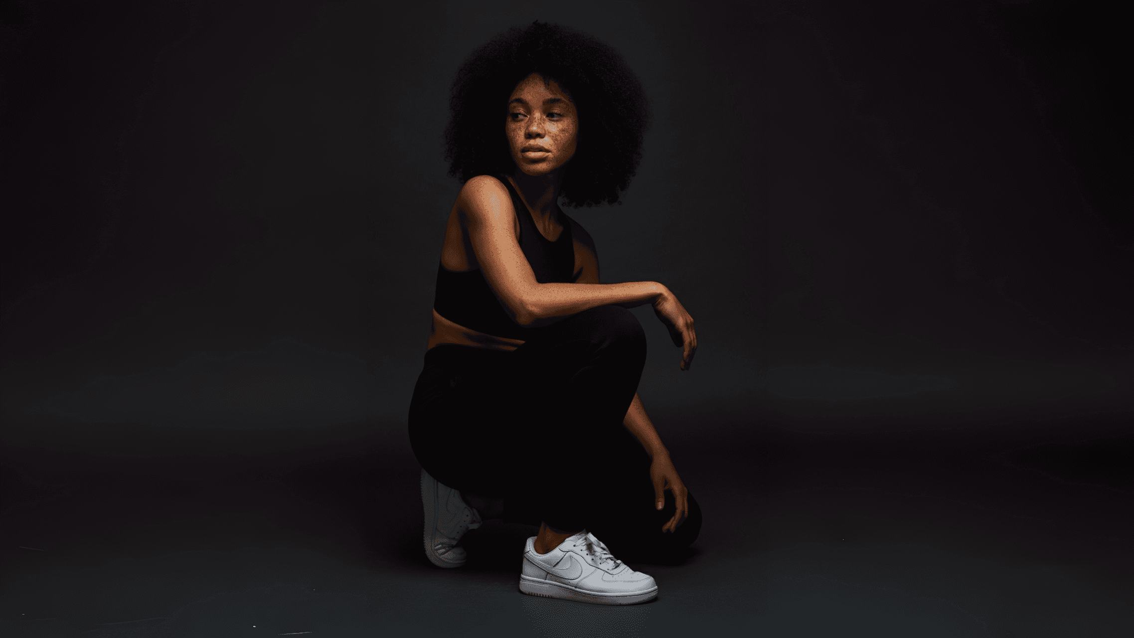 Woman posing in a black sports outfit.