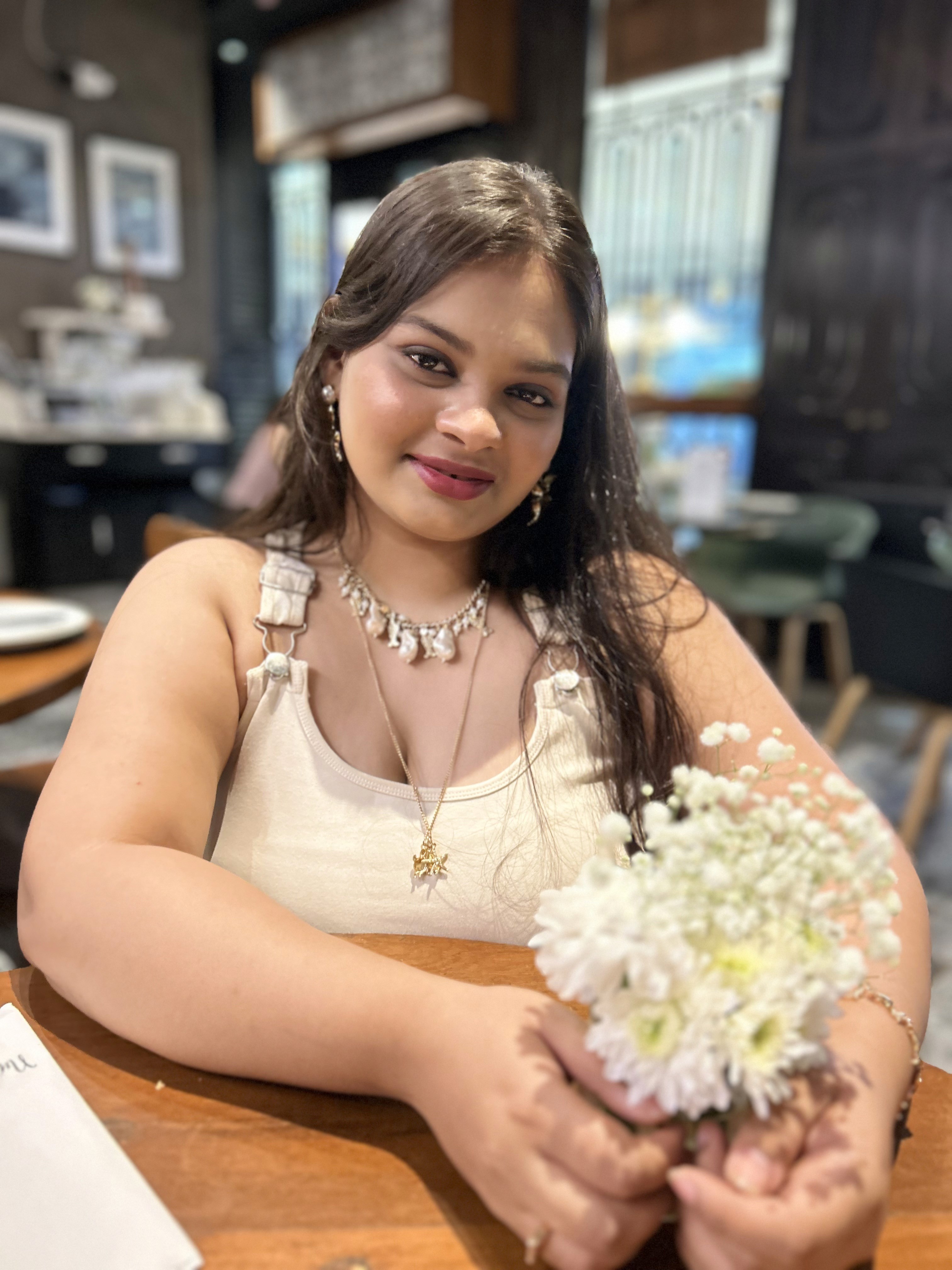 A thoughtful young person with dark hair gazes to the side, captured in soft black and white lighting.
