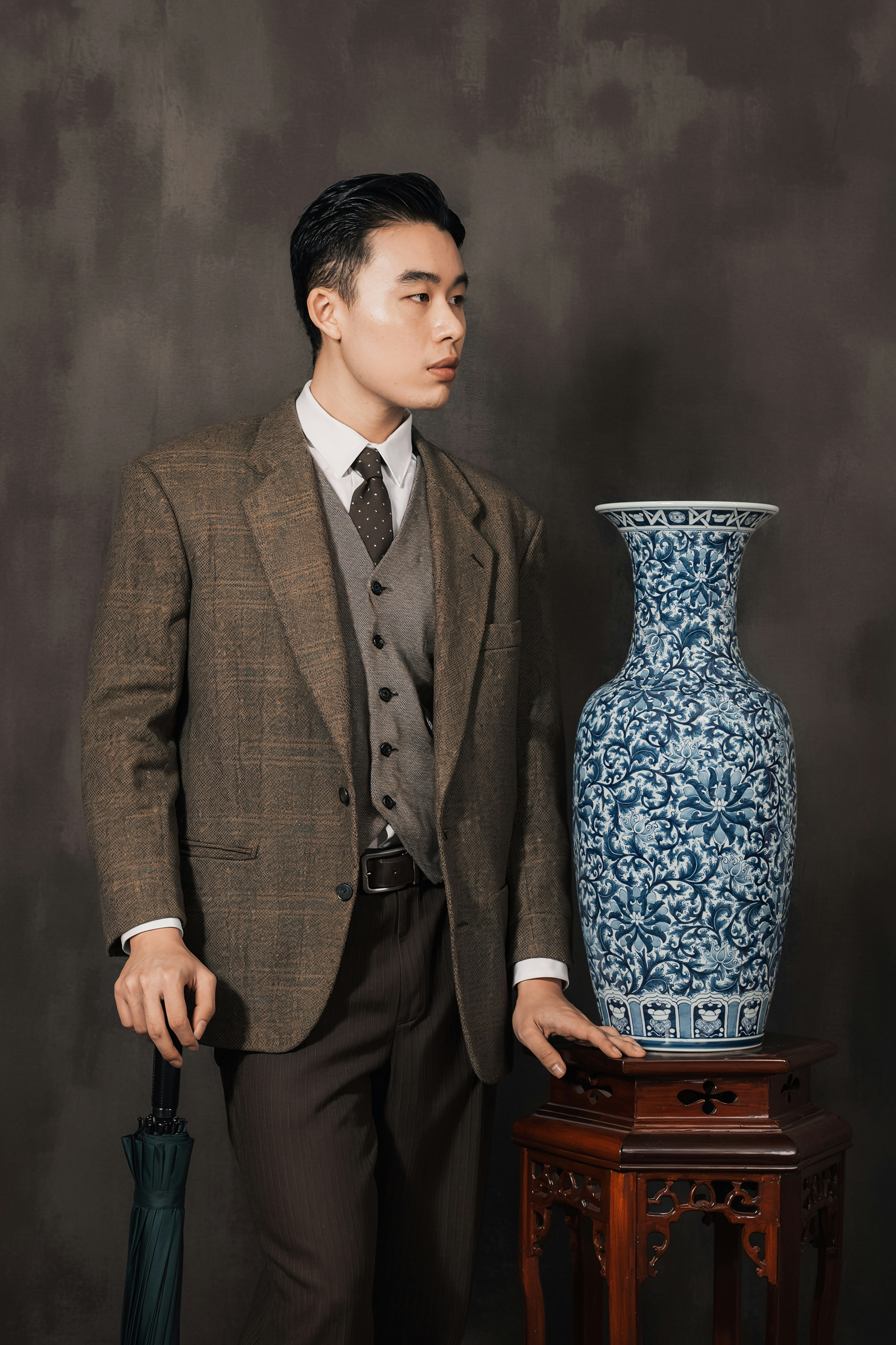 A man standing next to a blue and white vase