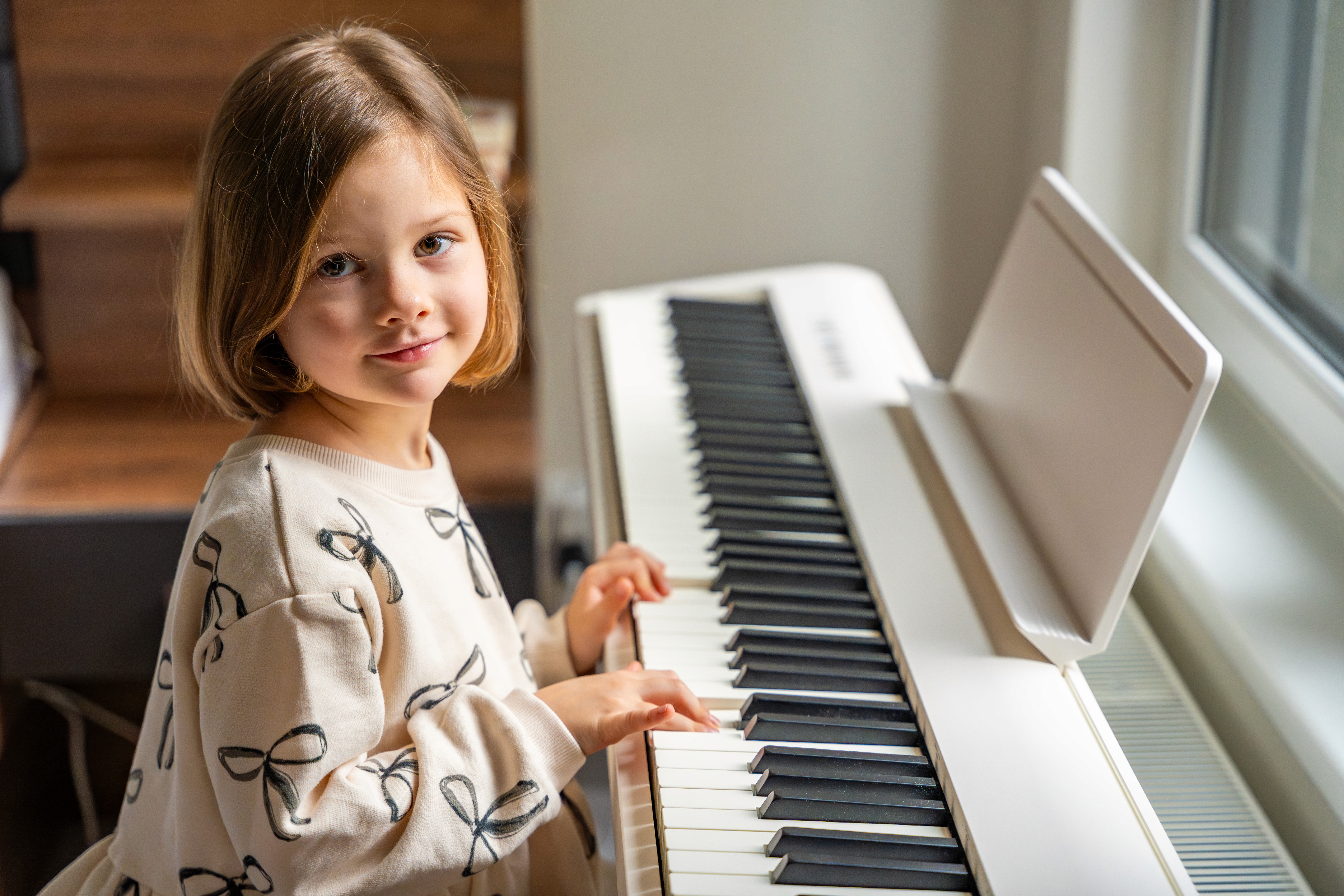 Kind spielt Klavier zu Hause beim Musikunterricht für Anfänger