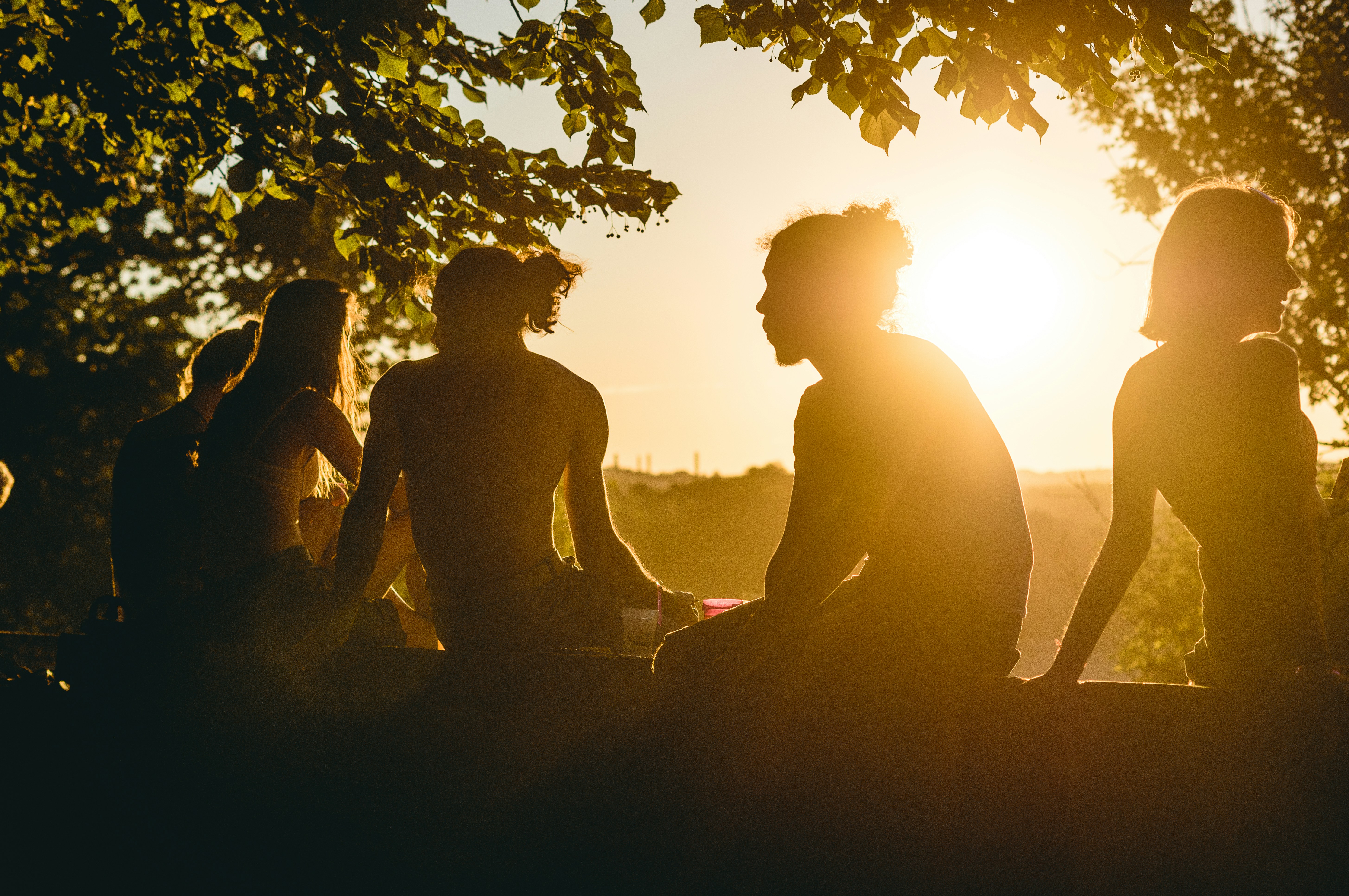 Woman with hands in prayer position meditating at sunset.