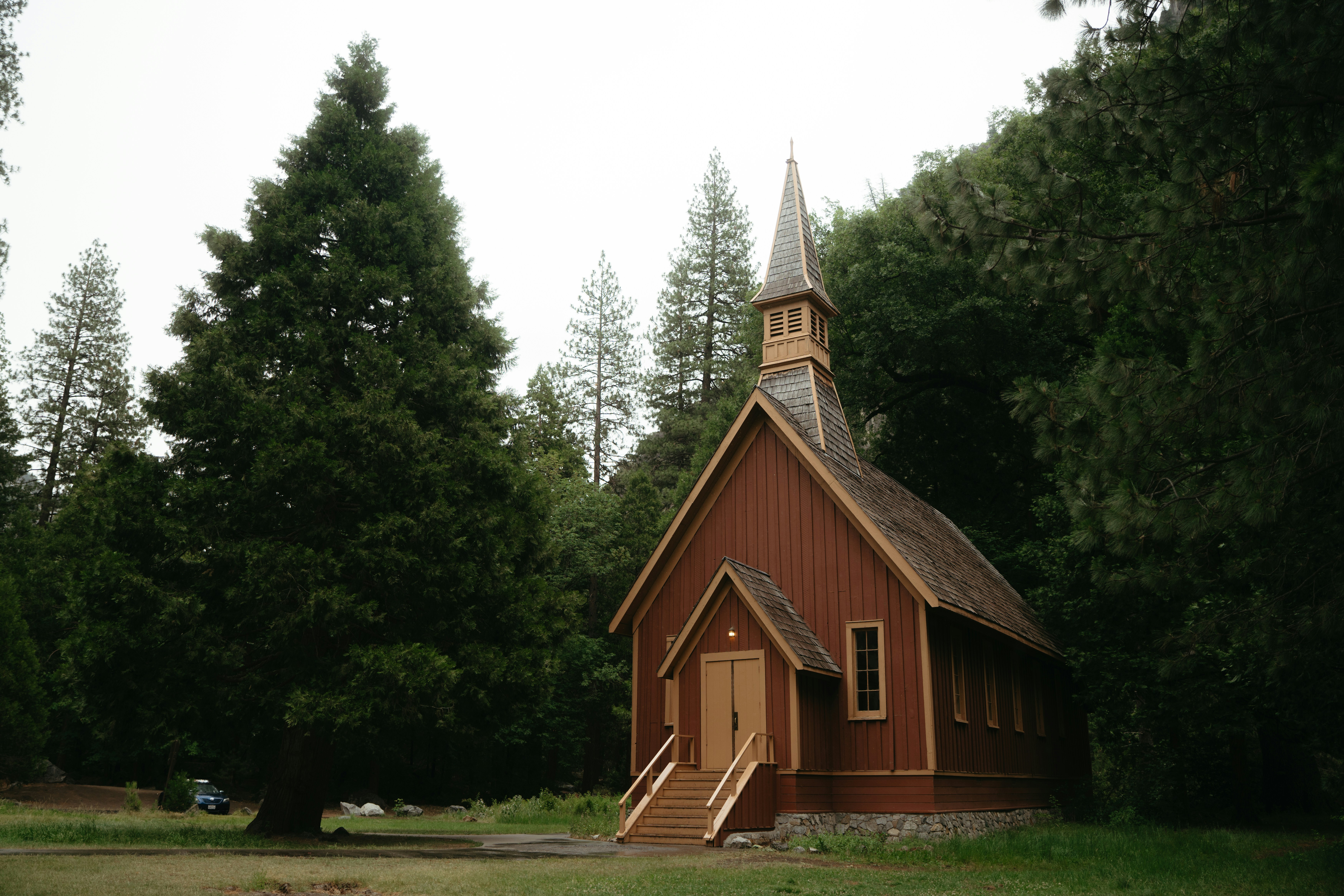 Small wooden chapel surrounded by tall trees