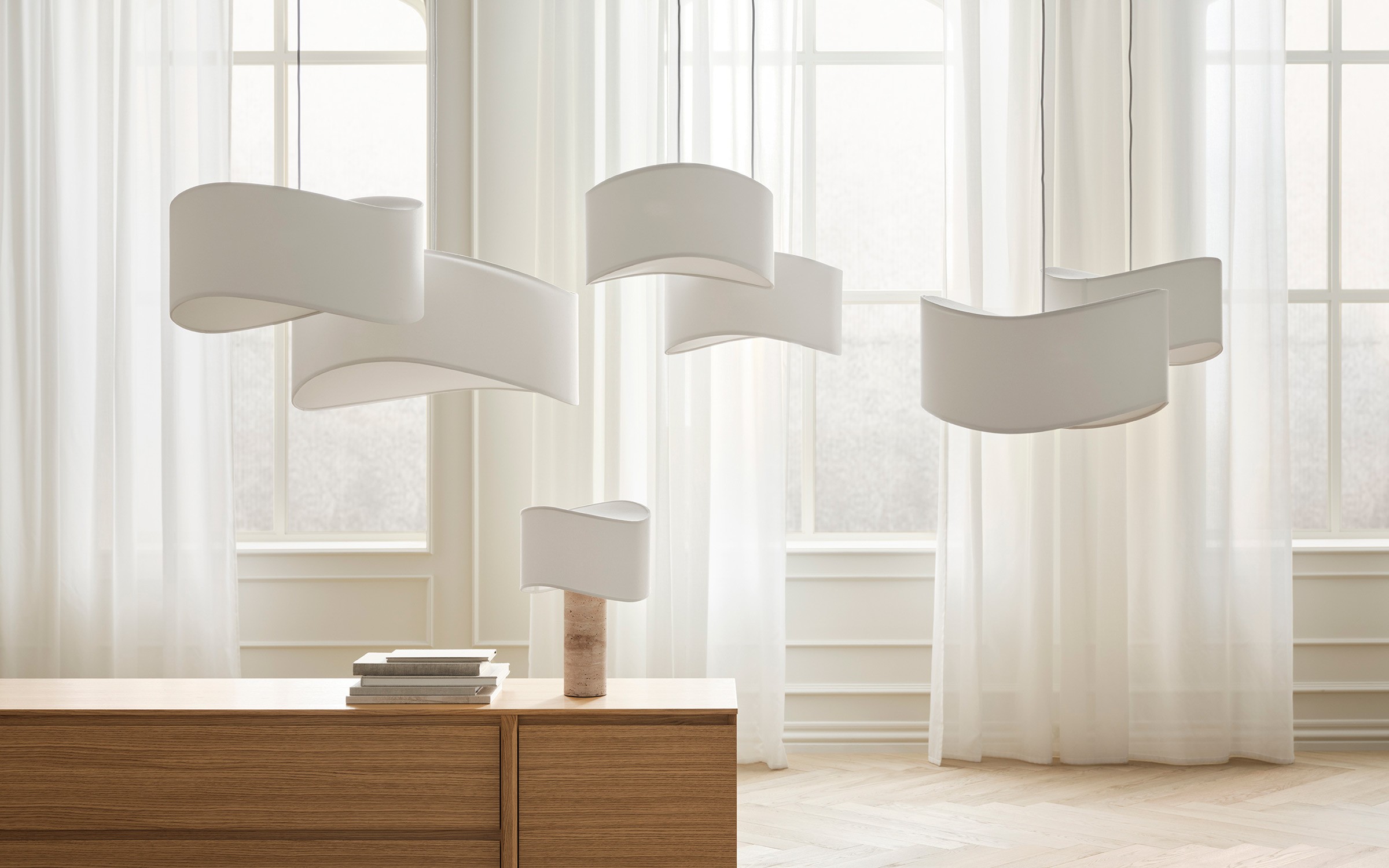 Tajo lighting series with sculptural white pendants and table lamp in airy interior designed by Asger Risborg Jakobsen