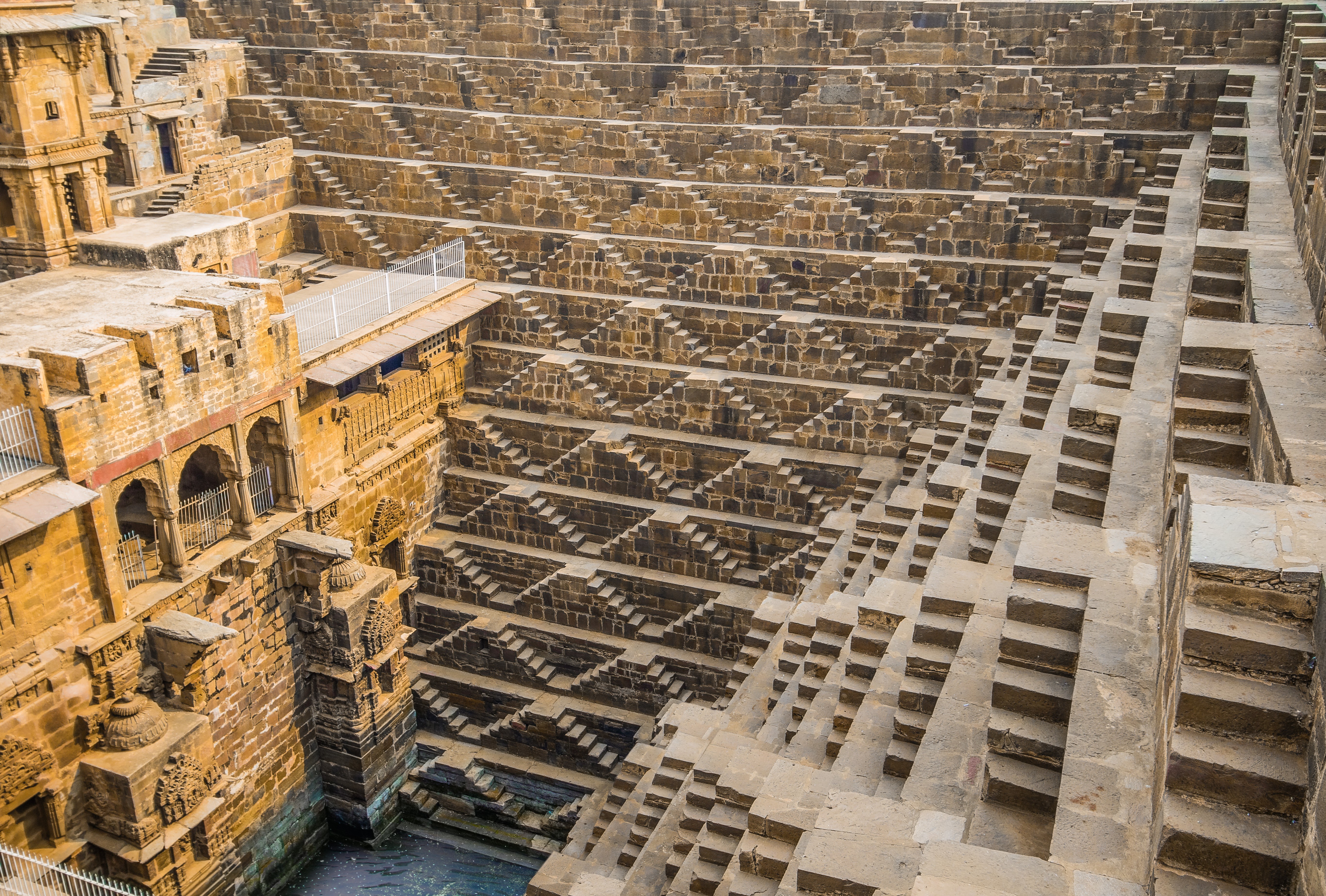 A vast and intricate stepwell known as Chand Baori in Rajasthan, India, featuring symmetrical staircases descending deep into the earth