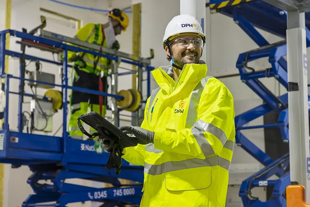 Modern glass building with illuminated trees and a view of city skyscrapers