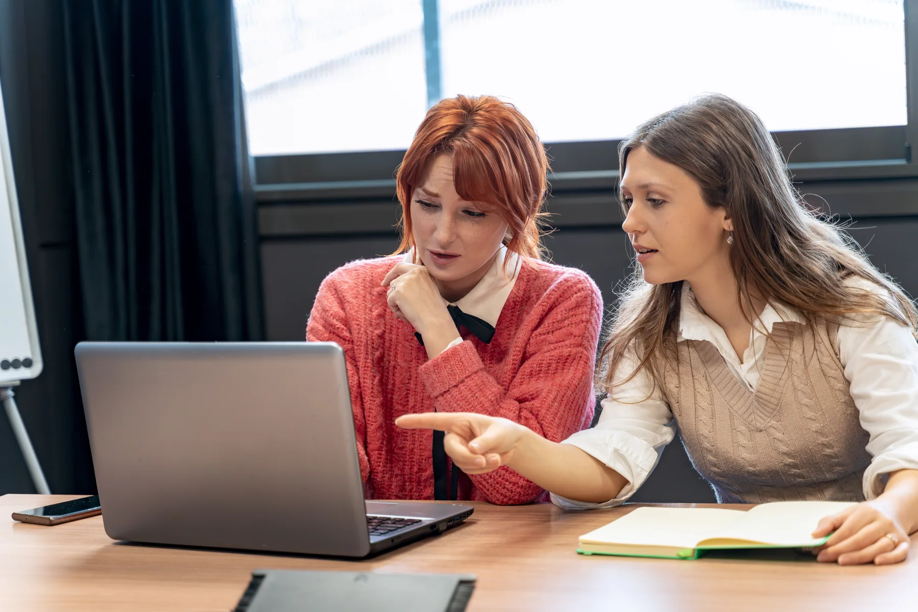 Two Women Collaborating on Laptop in Modern Office