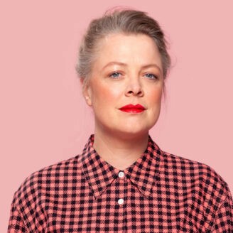 Person wearing a striped shirt and red stripes standing against the background.
