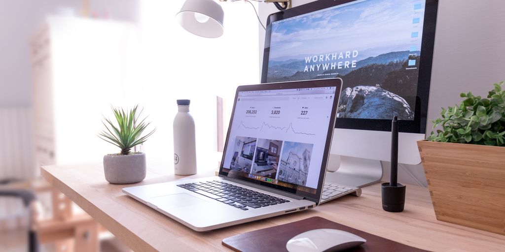 MacBook Pro on table beside white iMac and Magic Mouse