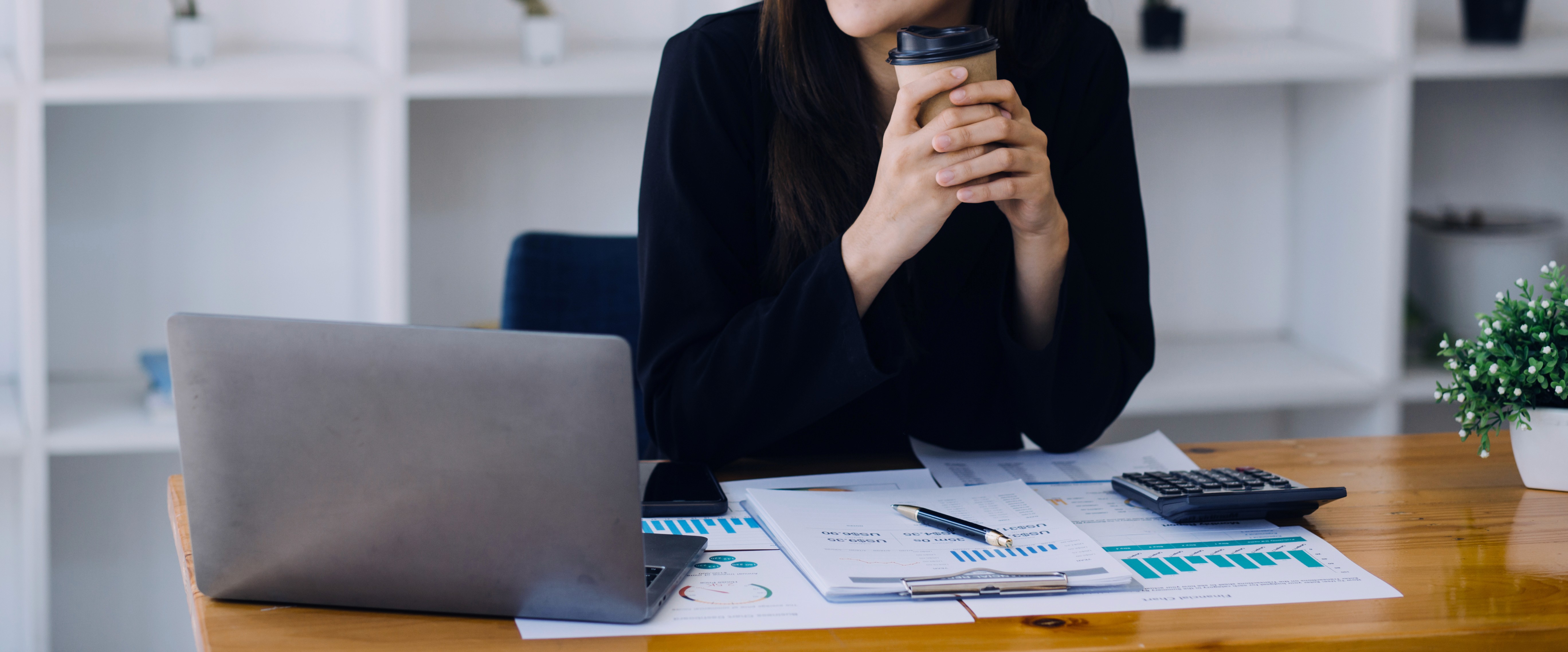 a group of people sitting around a table with laptops