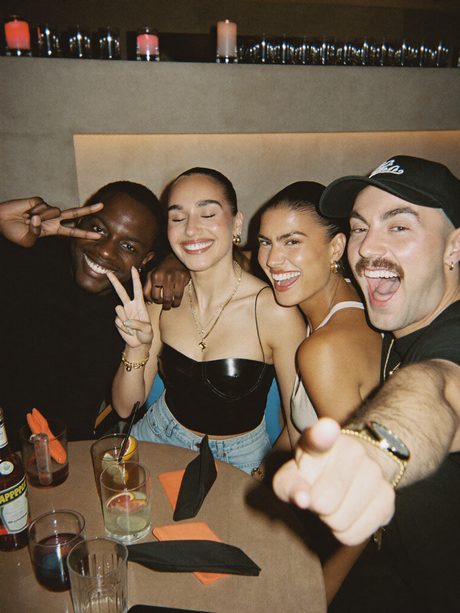 Four friends at a bar, laughing