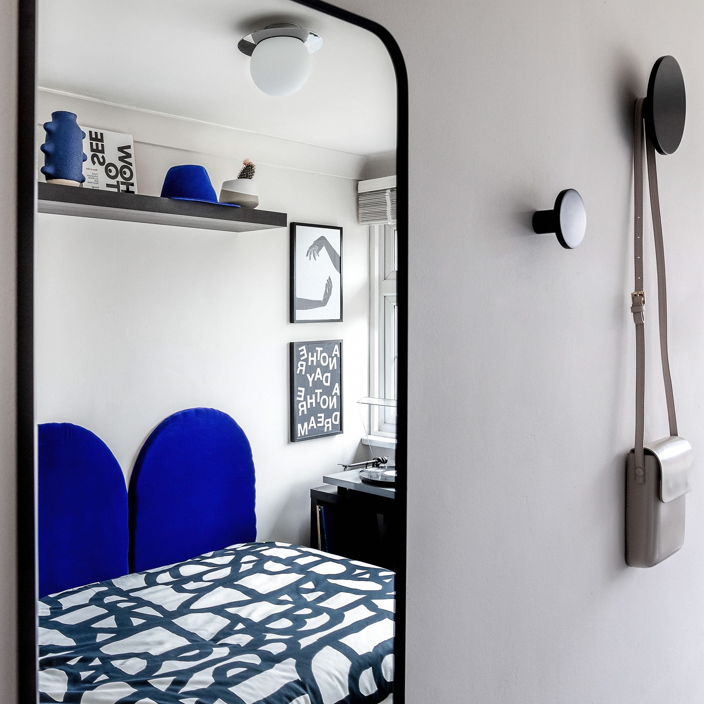 Bespoke electric blue arched material headboard and geometric details in a teenager's room of a London new build for a refugee family, created by Atelier Akuko.