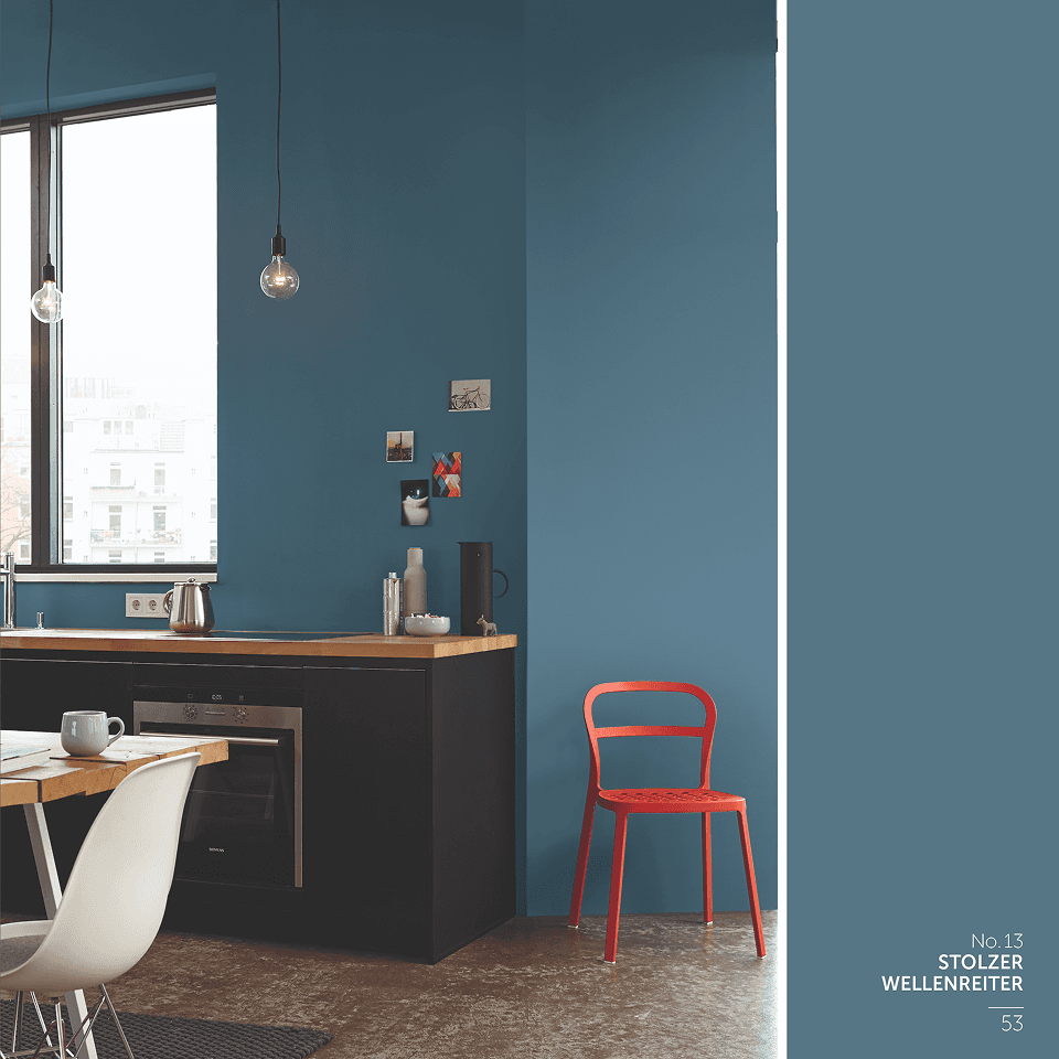 Alpina Feine Farben Editorial – aufgeschlagenes Farbbuch zur „Farbfamilie Grau" mit Architekturfotografie, Pigment-Stillleben und Farbtönen „Stärke der Berge", „Nebel im November", „Poesie der Stille" und „Zeit der Eisblumen", vor schwarzem Hintergrund.
