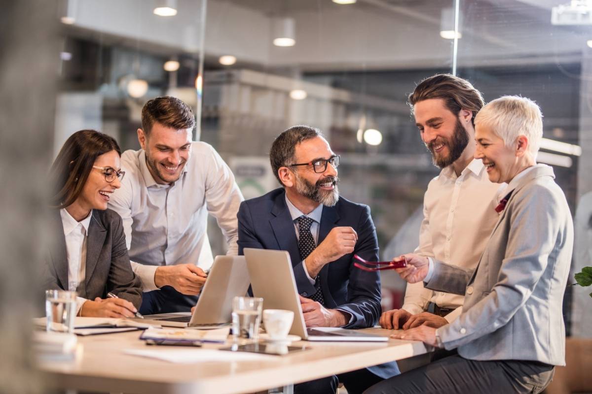 Some people working together at a table with laptops.