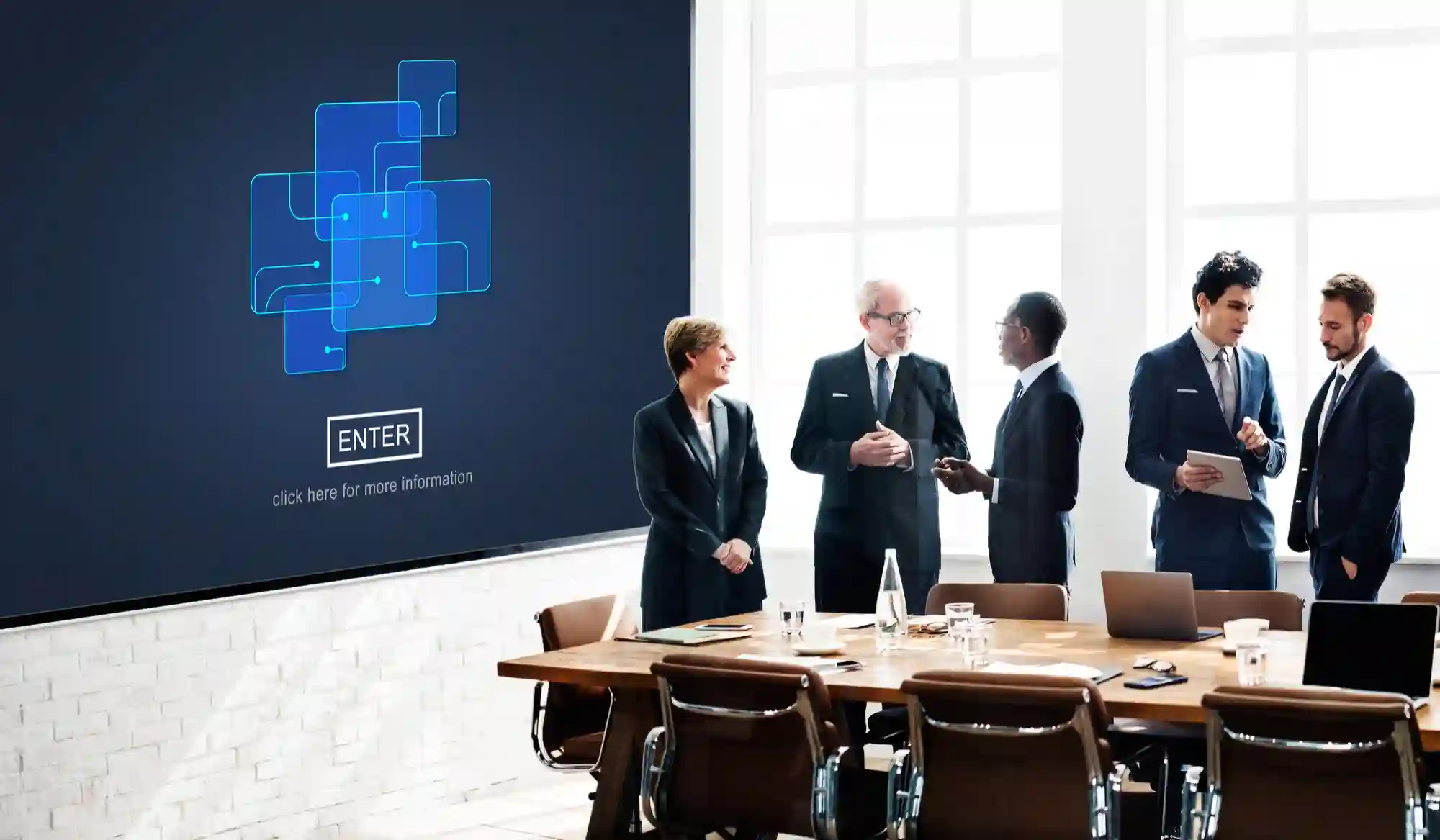 A professional team in a modern boardroom collaborating on data solutions displayed on a large digital presentation screen.