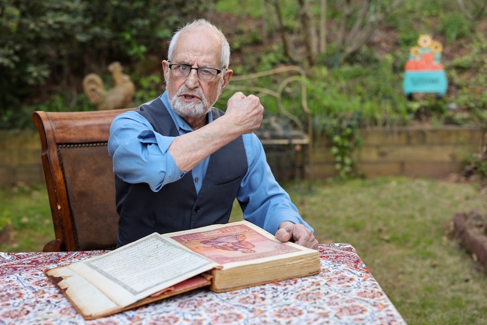 Bubjan with book and speaking to camera