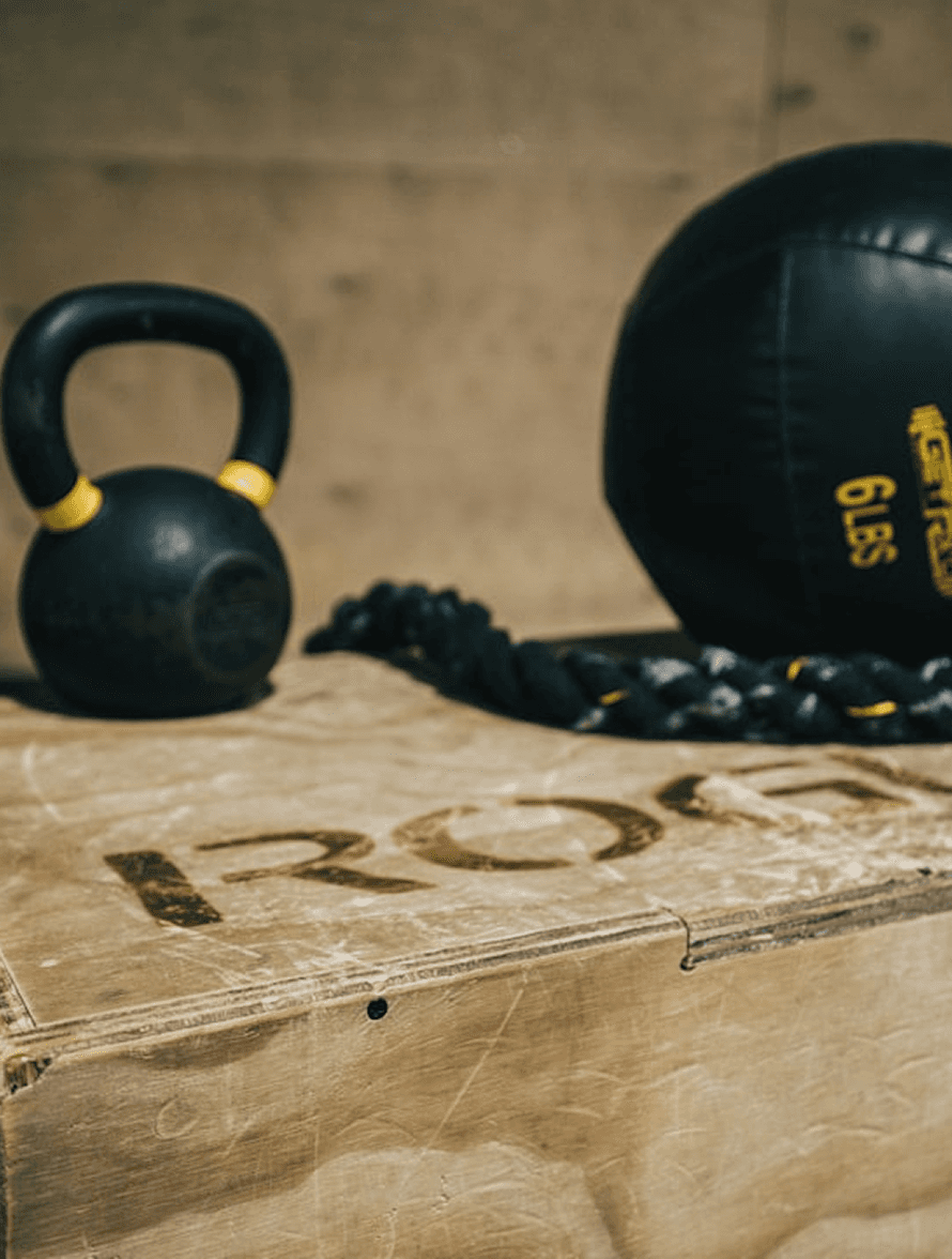 Close-up of a heavy barbell plate in a dark-themed gym representing strength and hypertrophy training.