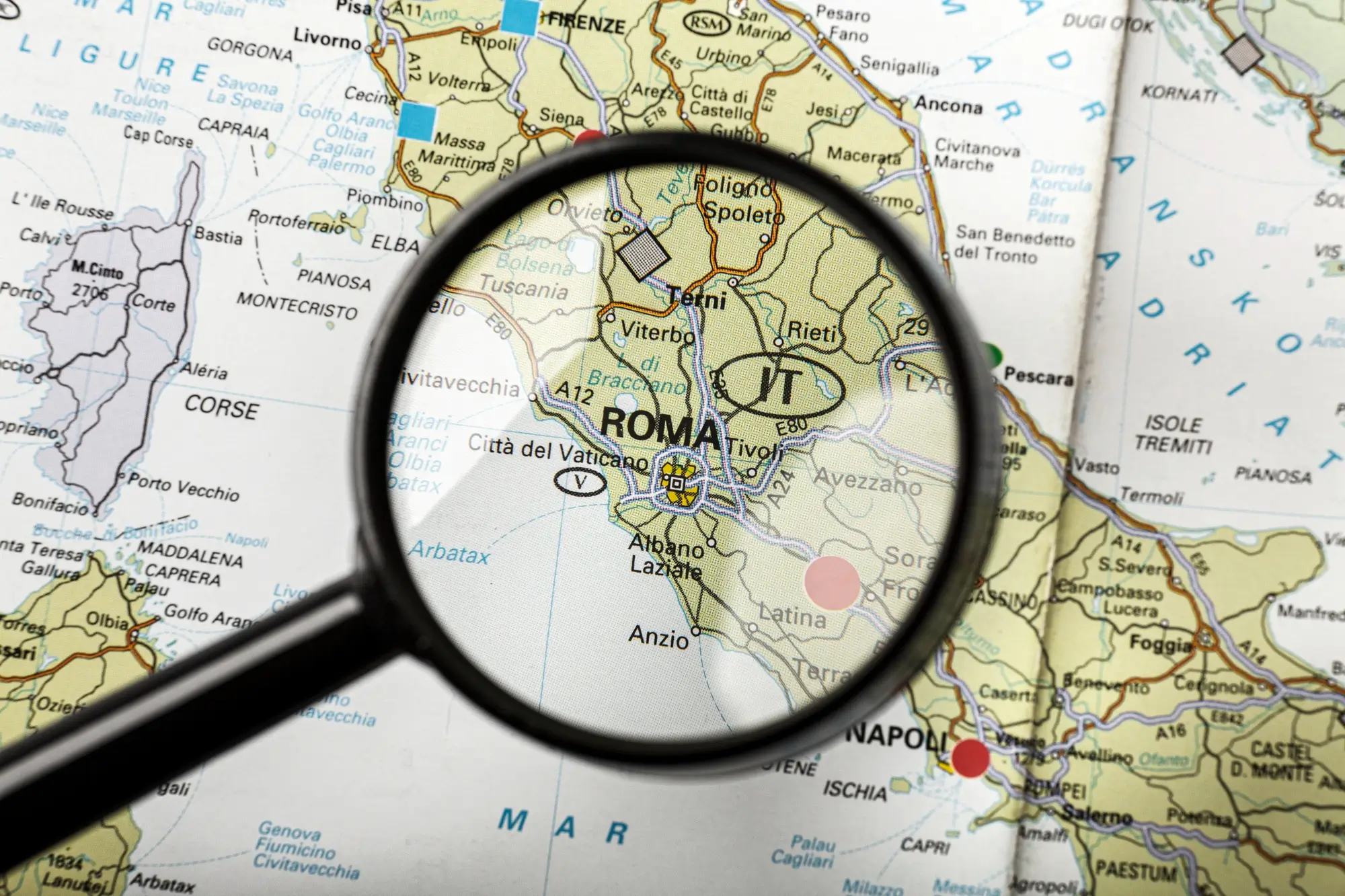 Büyüteç altında Roma’yı gösteren İtalya haritası.