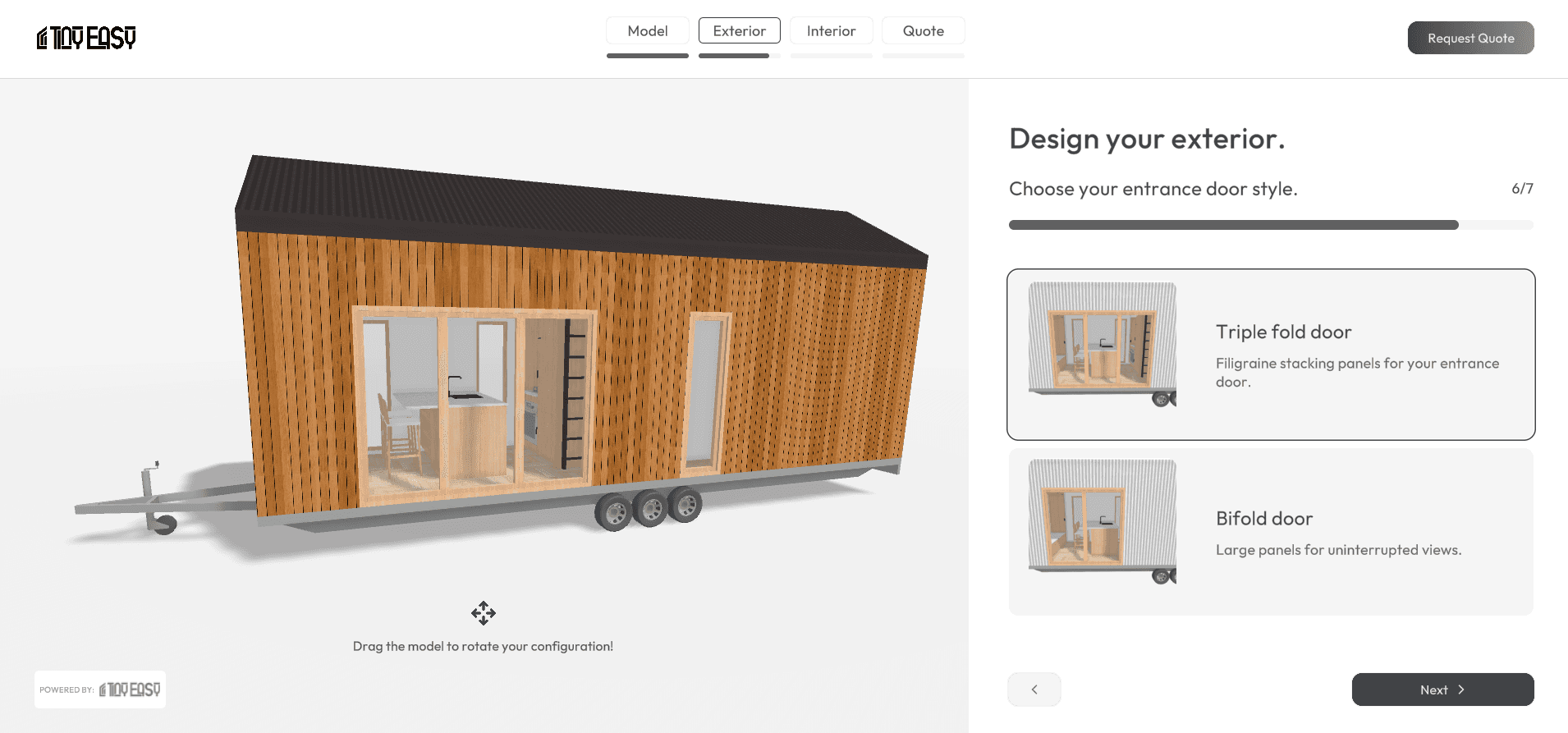 A 3D image of a tiny home on wheels in a product configurator. The tiny home is wooden and has a triple fold door.