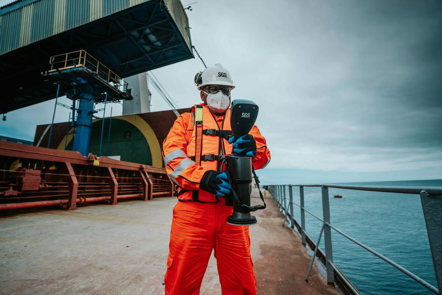 Marine surveyor on a bulk carrier deck using electronic measuring equipment during a draft survey, supporting accurate cargo quantity determination and shortage dispute prevention.