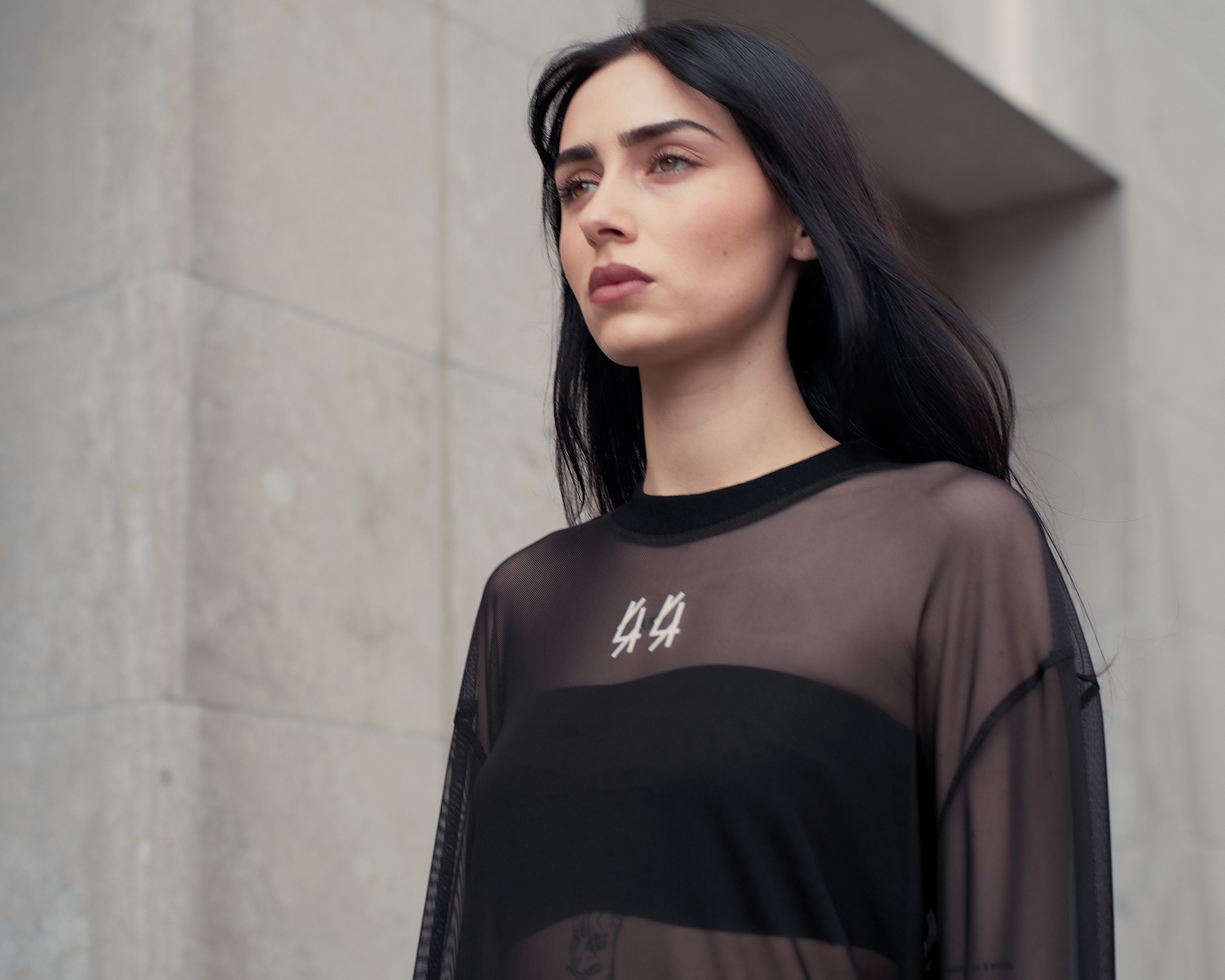 Model in schwarzer transparenter Kleidung in einer Szene aus einem Fashion Video