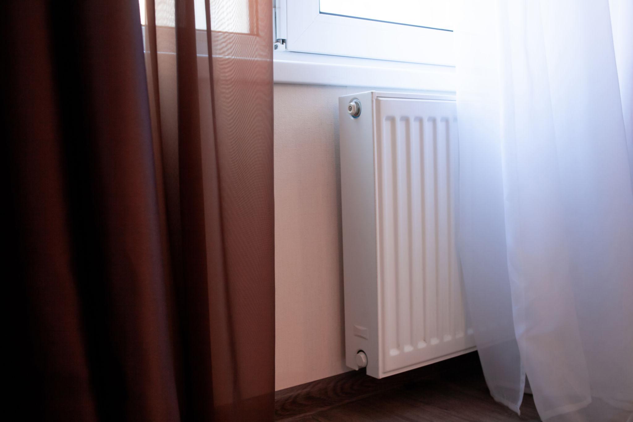 Undersized panel radiator on a wall in a UK home that failed to heat the room adequately after air source heat pump installation