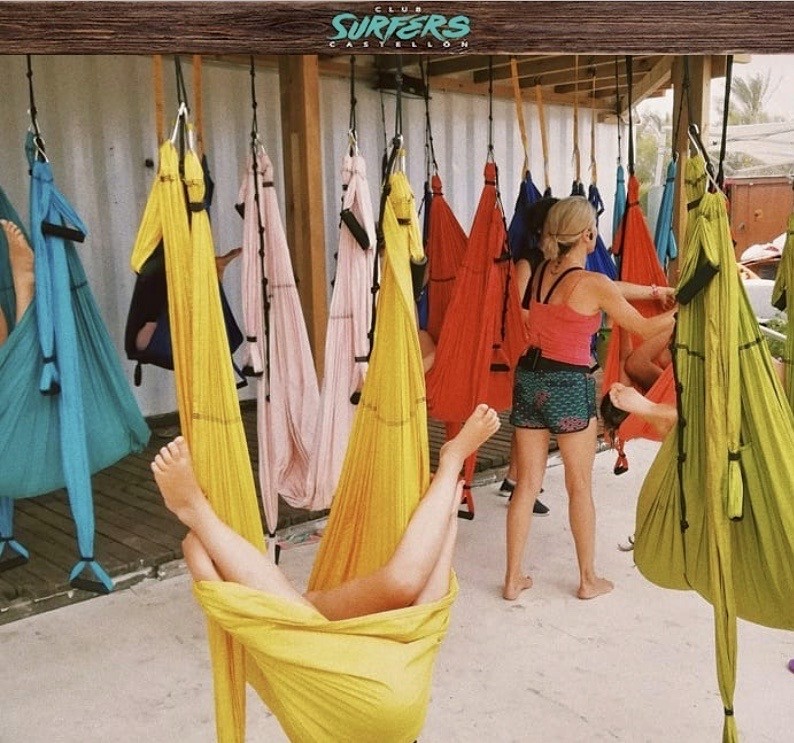 niños realizando yoga aereo en la playa