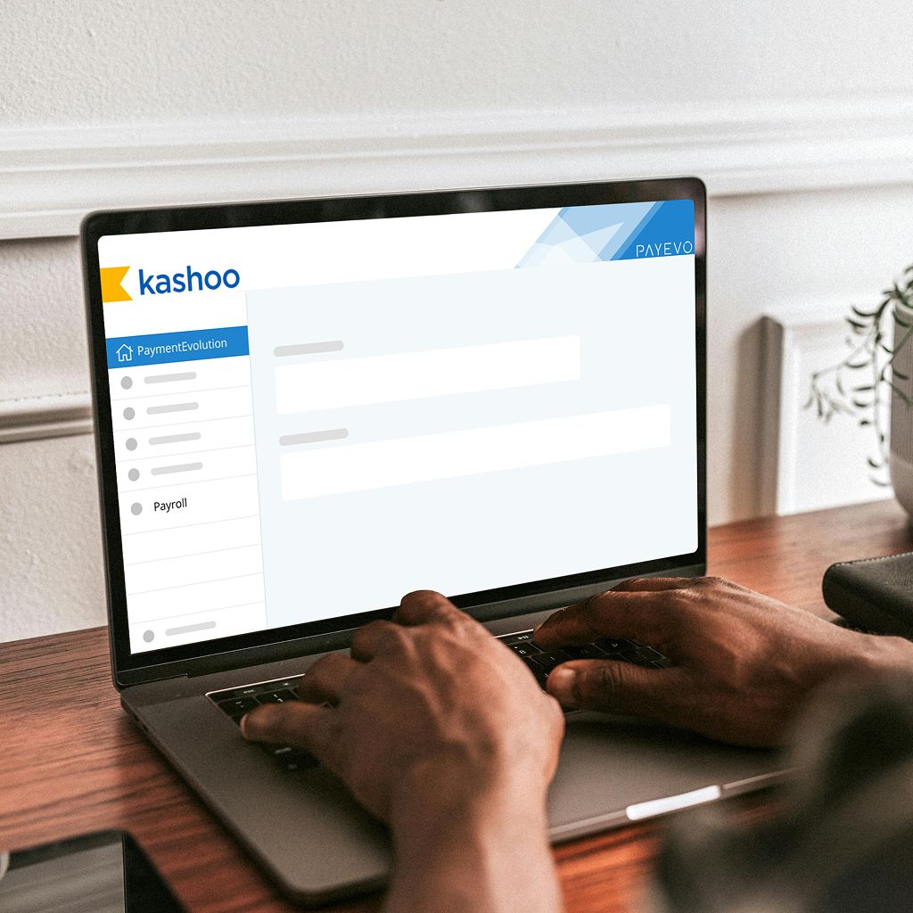 Laptop displaying Kashoo accounting software with PaymentEvolution integration showing payroll navigation menu