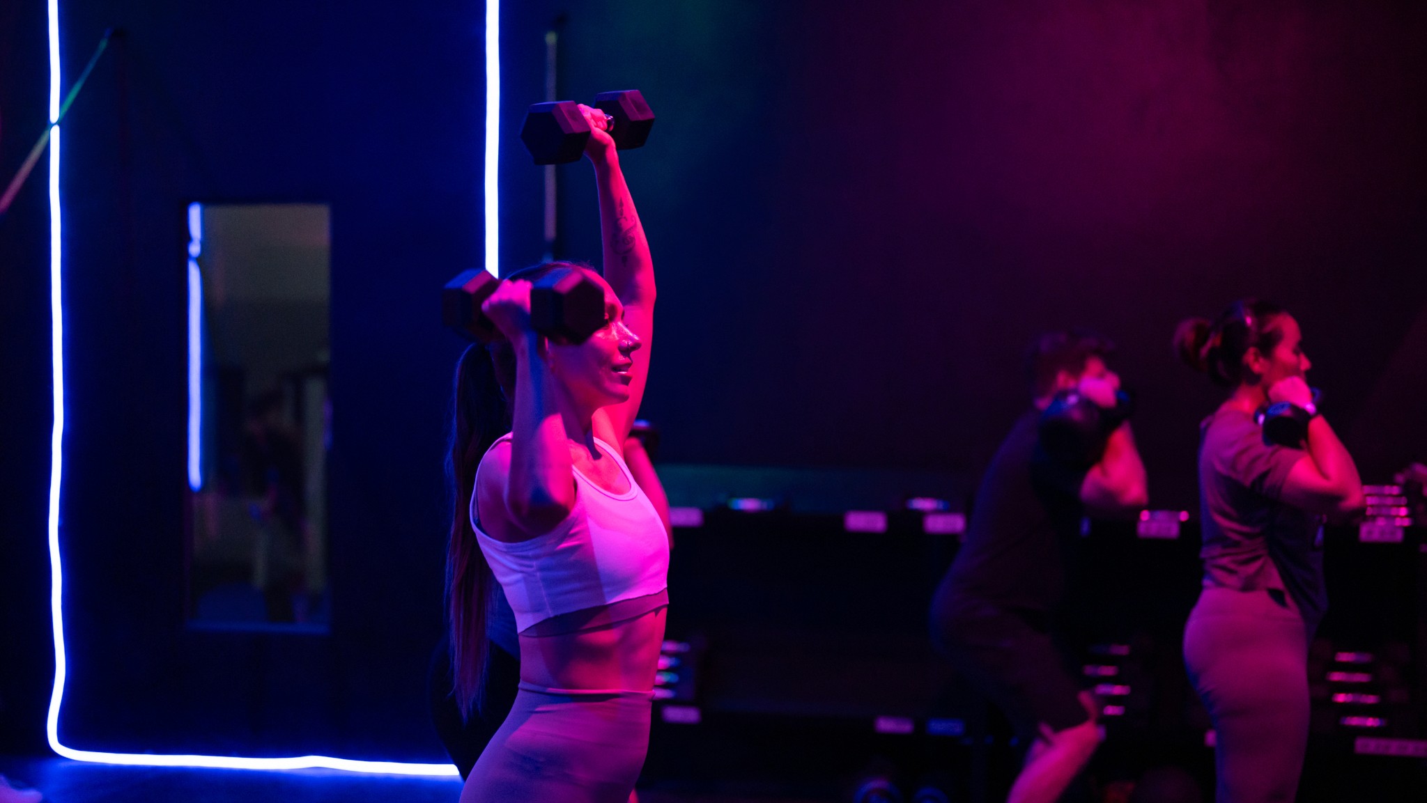 Dynamic Circuit Training session at Legacy Muscle Universe Koh Samui, with group fitness exercises in a neon-lit studio for all levels.
