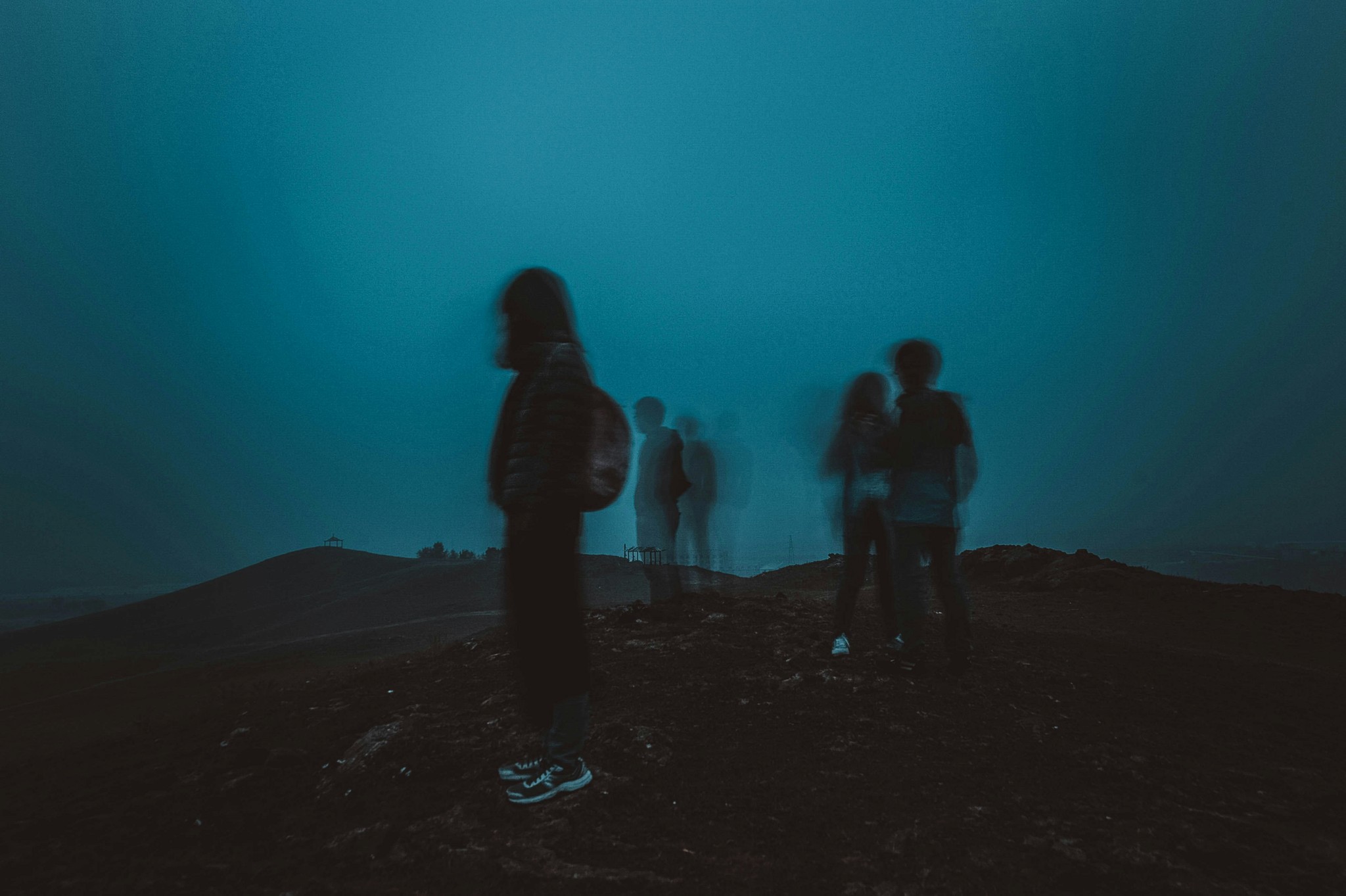 People on dark hill at night