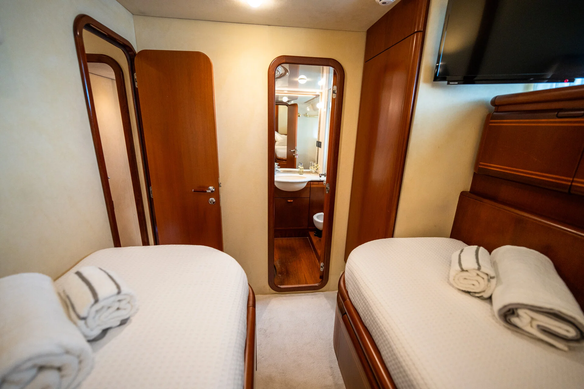 White Rock 36 speedboat with captain at helm cruising calm blue waters near Paros coastline with hills in background.