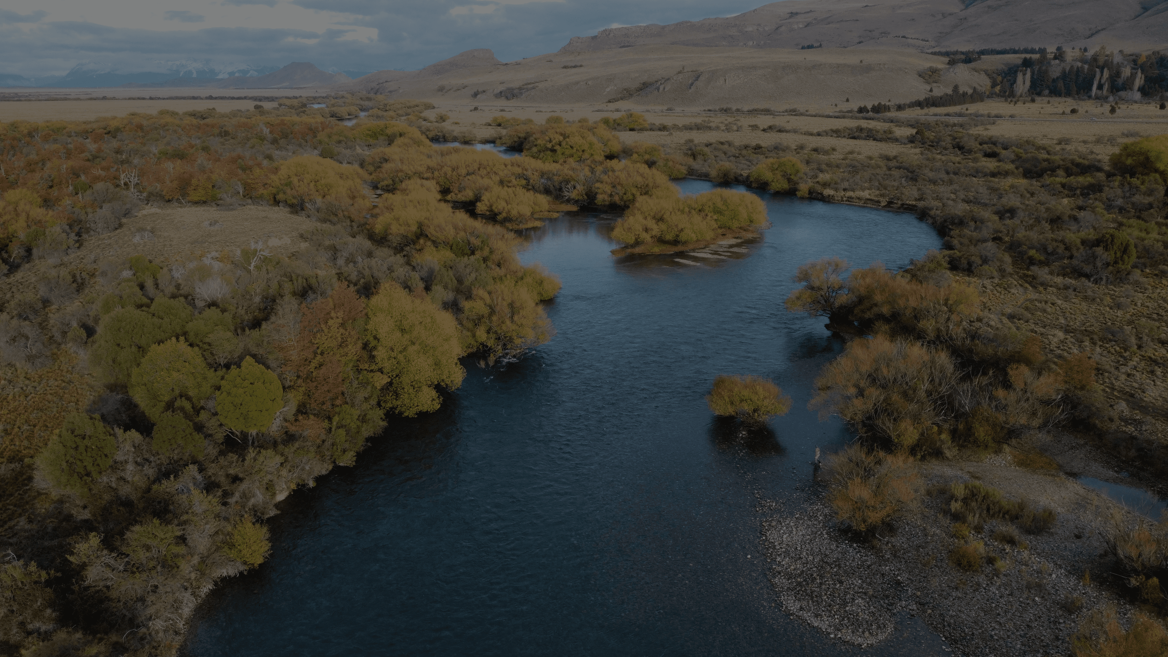 a river running through a valley surrounded by mountains
