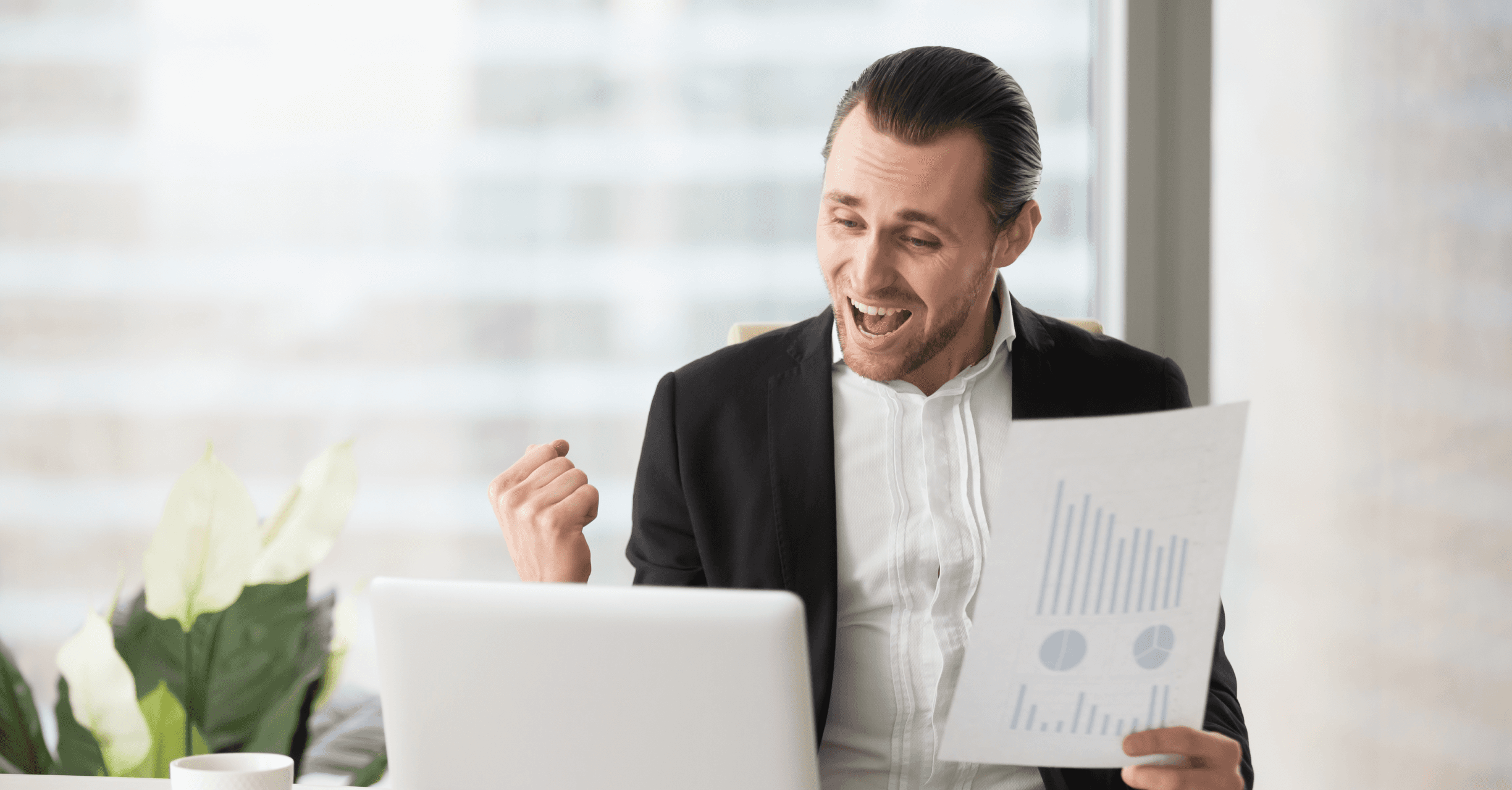 Excited man holding financial report