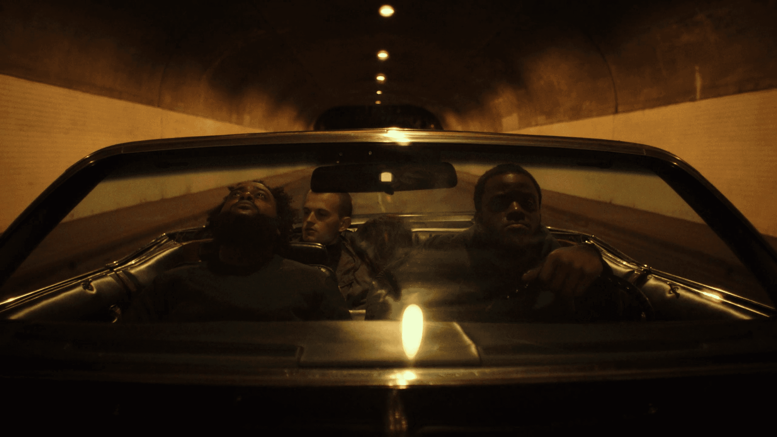 A person walks down a dimly lit alley at night.