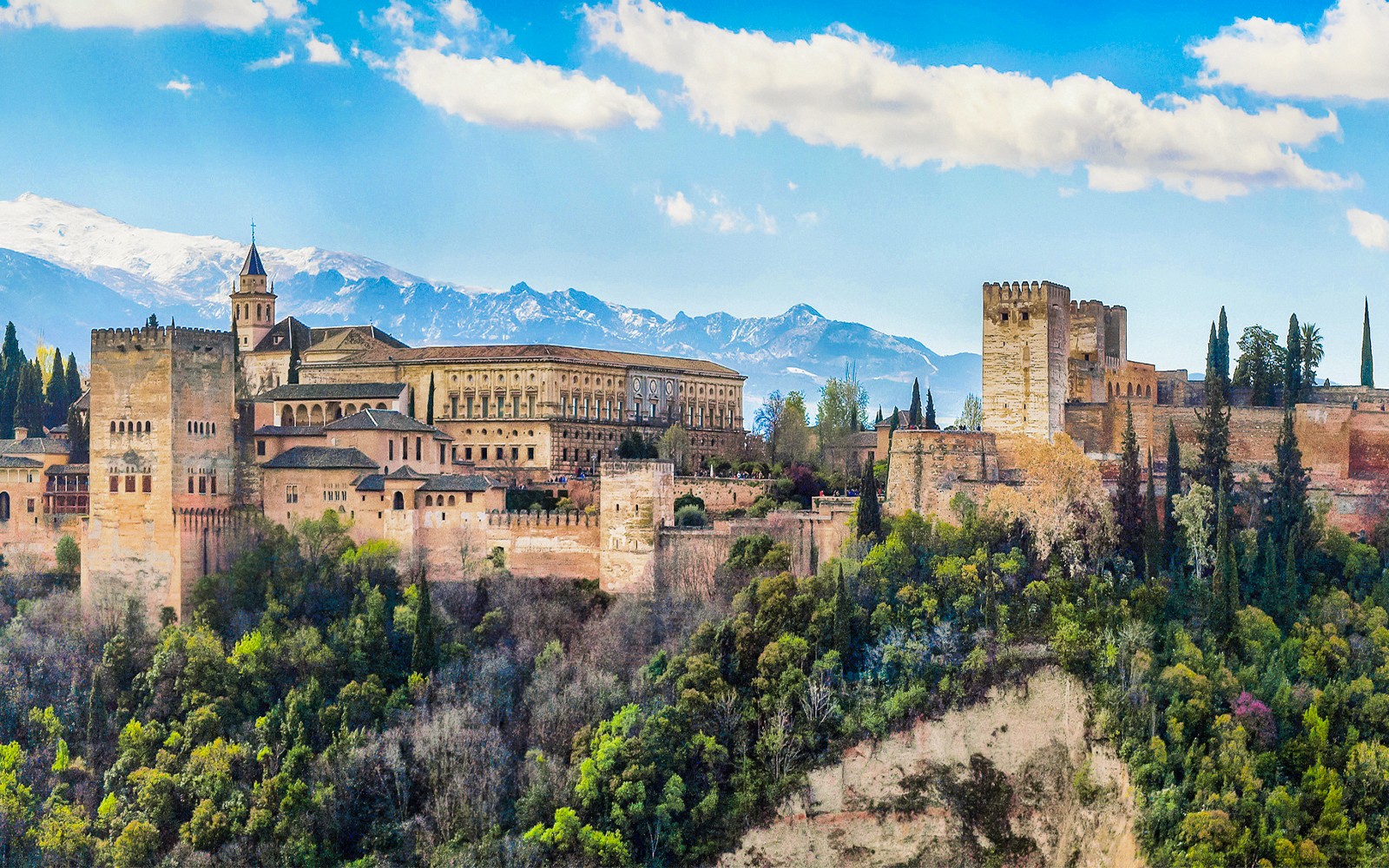 Alhambra-festningen i Granada, Spania, med naturskjønt fjellandskap i bakgrunnen.