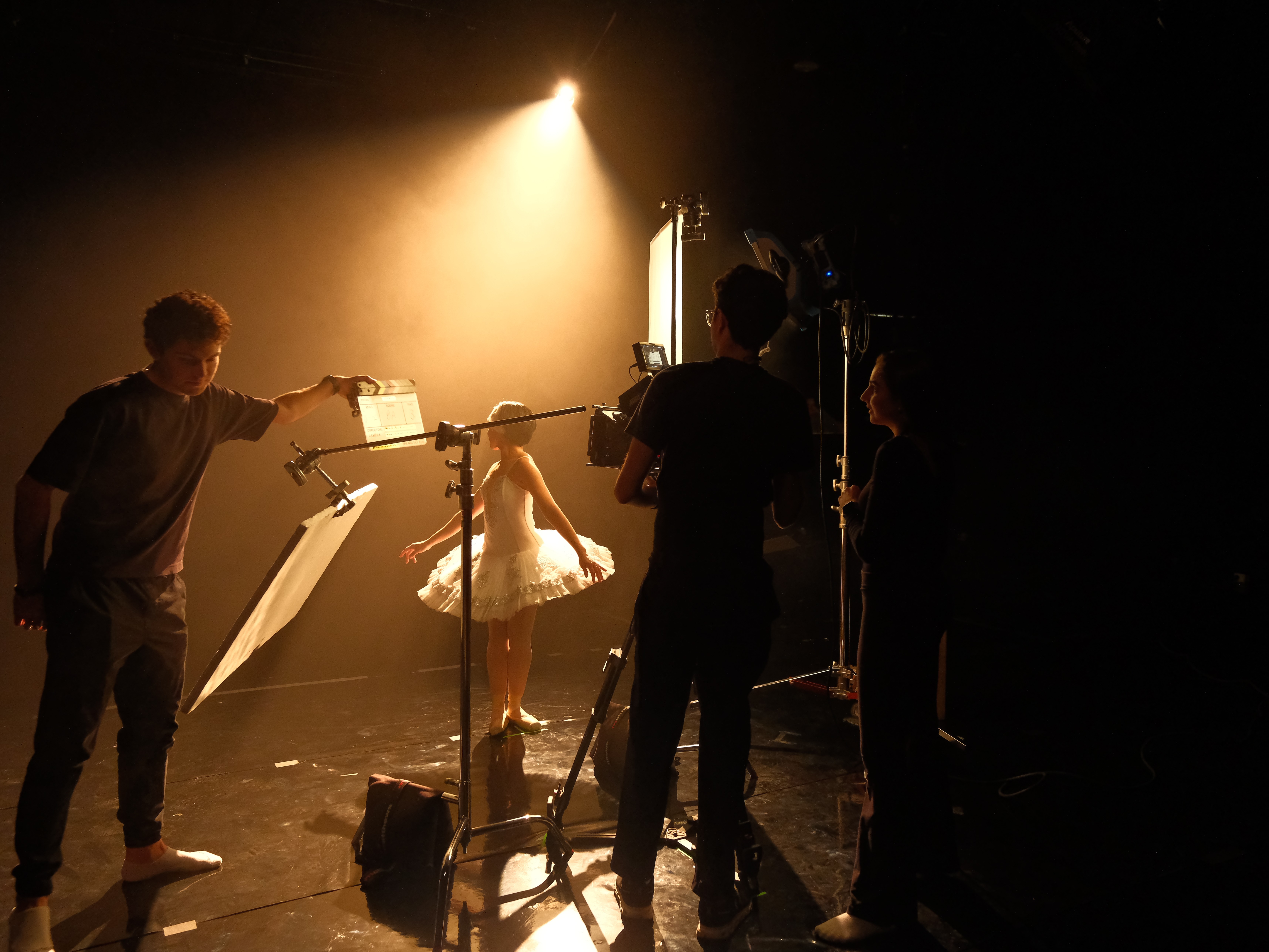 Cinematic studio production still of a ballet dancer illuminated by dramatic backlighting and haze. Photographed by Mexico City DP Mauricio Nader using an ARRI Alexa 35 with Cooke Mini S4i lenses, demonstrating high-end lighting design and professional crew management.