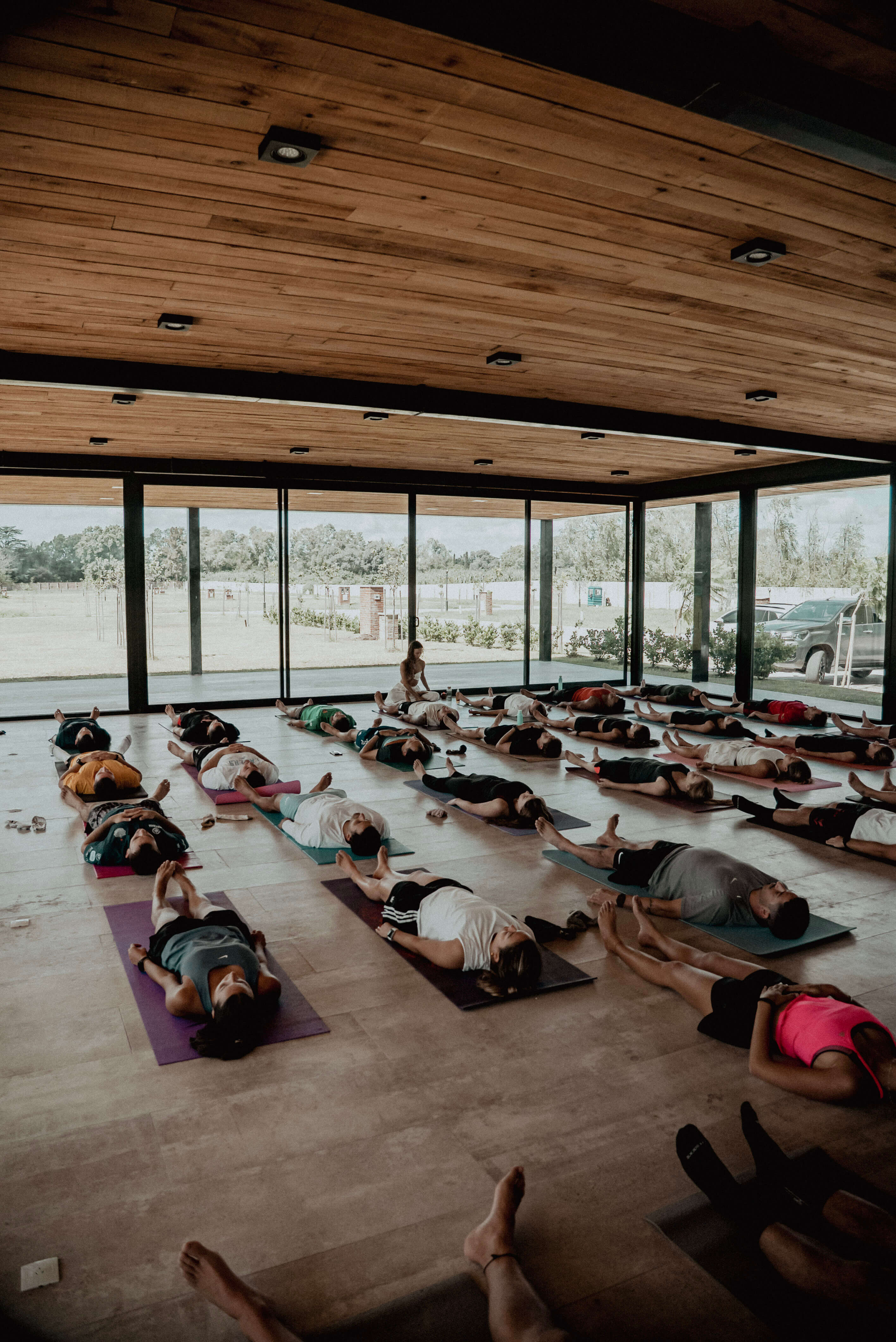 Personas practicando yoga en grupo sobre mats en un salón amplio y luminoso